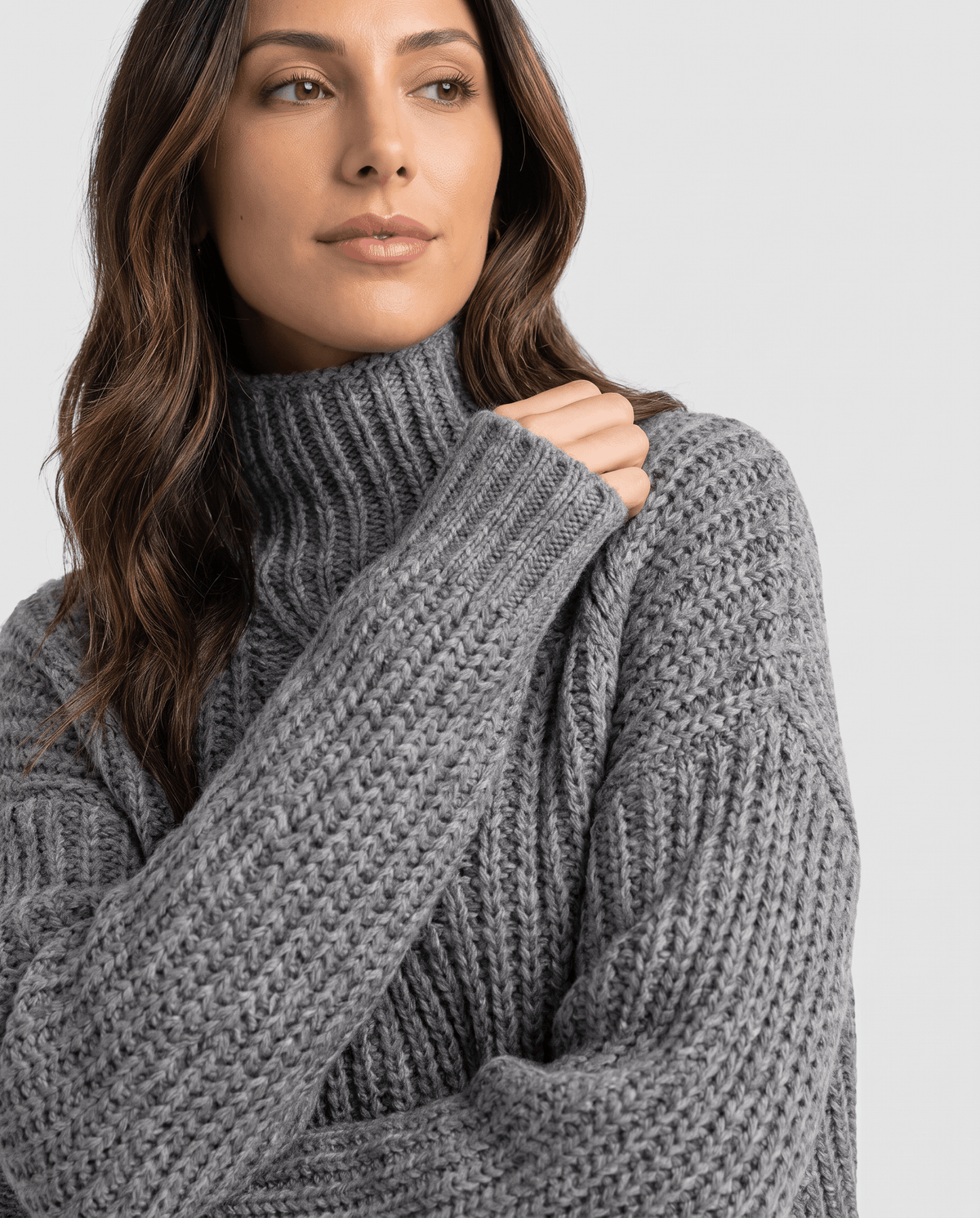 Close-up of the gray Chunky Cable Knit Sweater worn by a female model, showcasing the mock neck, chunky cable knit texture, and relaxed fit.