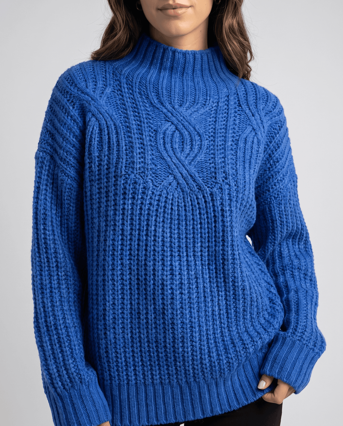 Blue Chunky Cable Knit Sweater worn by a female model, featuring a mock neck, relaxed fit, chunky cable knit texture, and long sleeves.