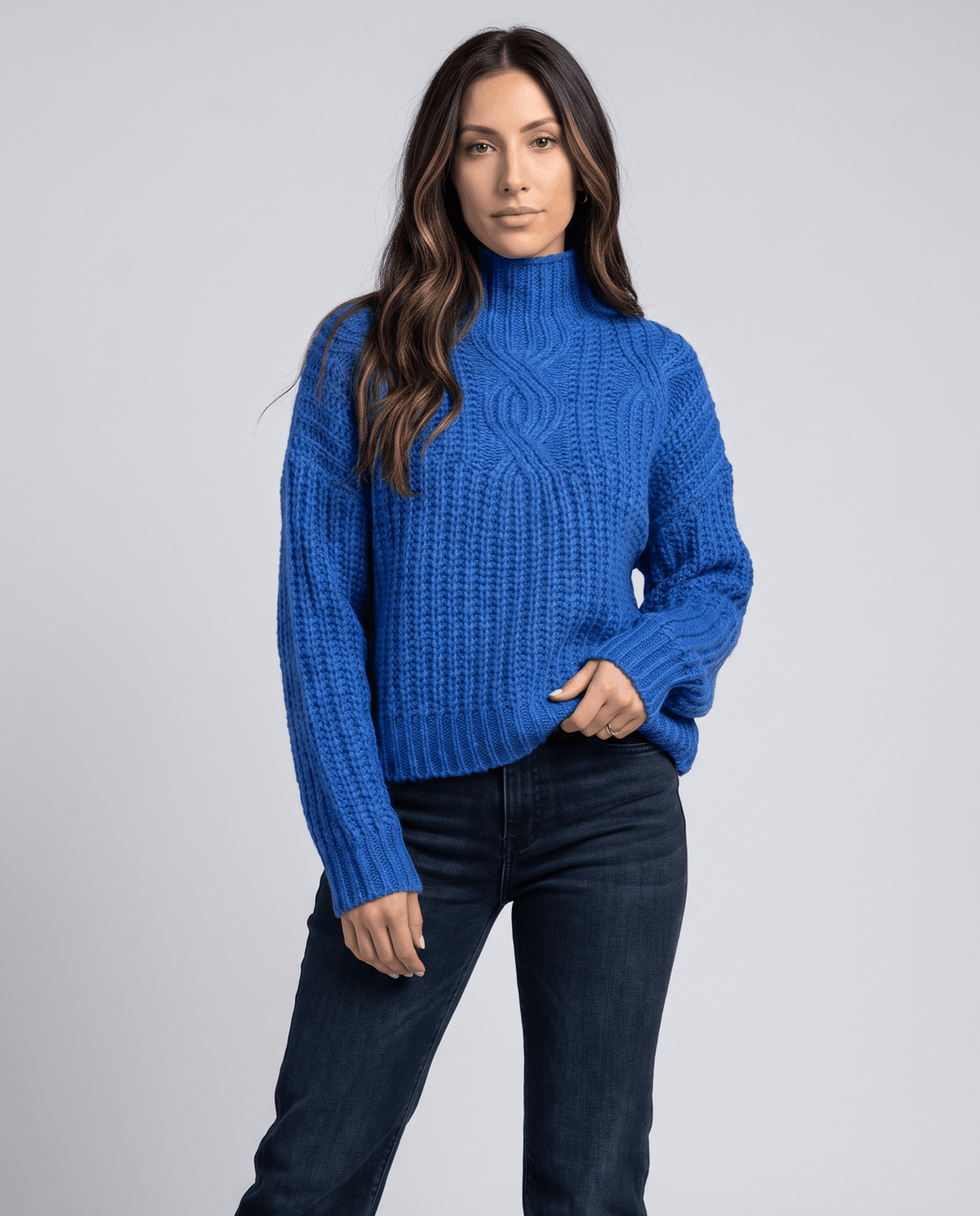 Blue Chunky Cable Knit Sweater worn by a female model, featuring a mock neck, relaxed fit, chunky cable knit texture, and long sleeves.