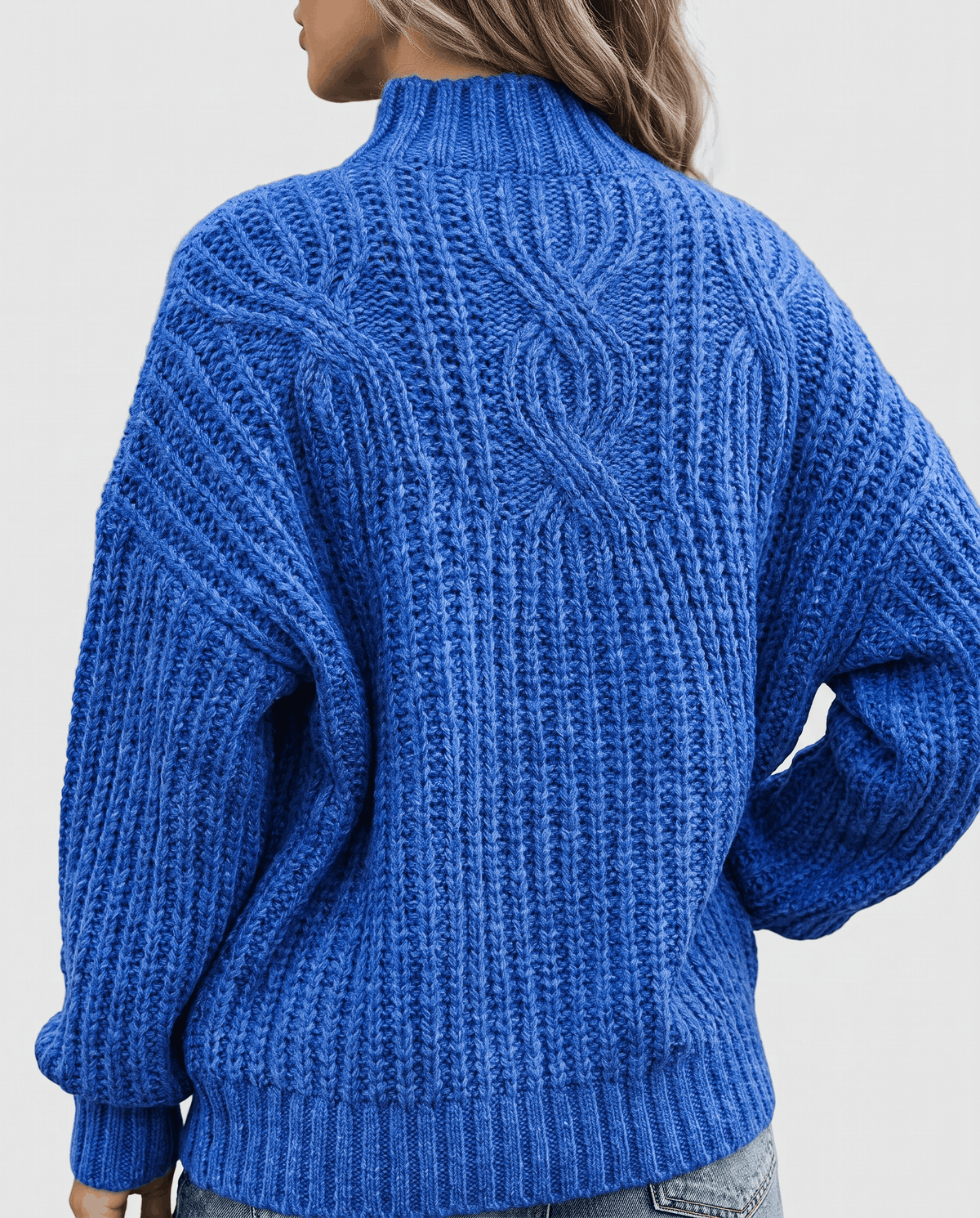Blue Chunky Cable Knit Sweater worn by a female model from the back, showcasing the chunky cable knit texture, mock neck, relaxed fit, and ribbed hem.