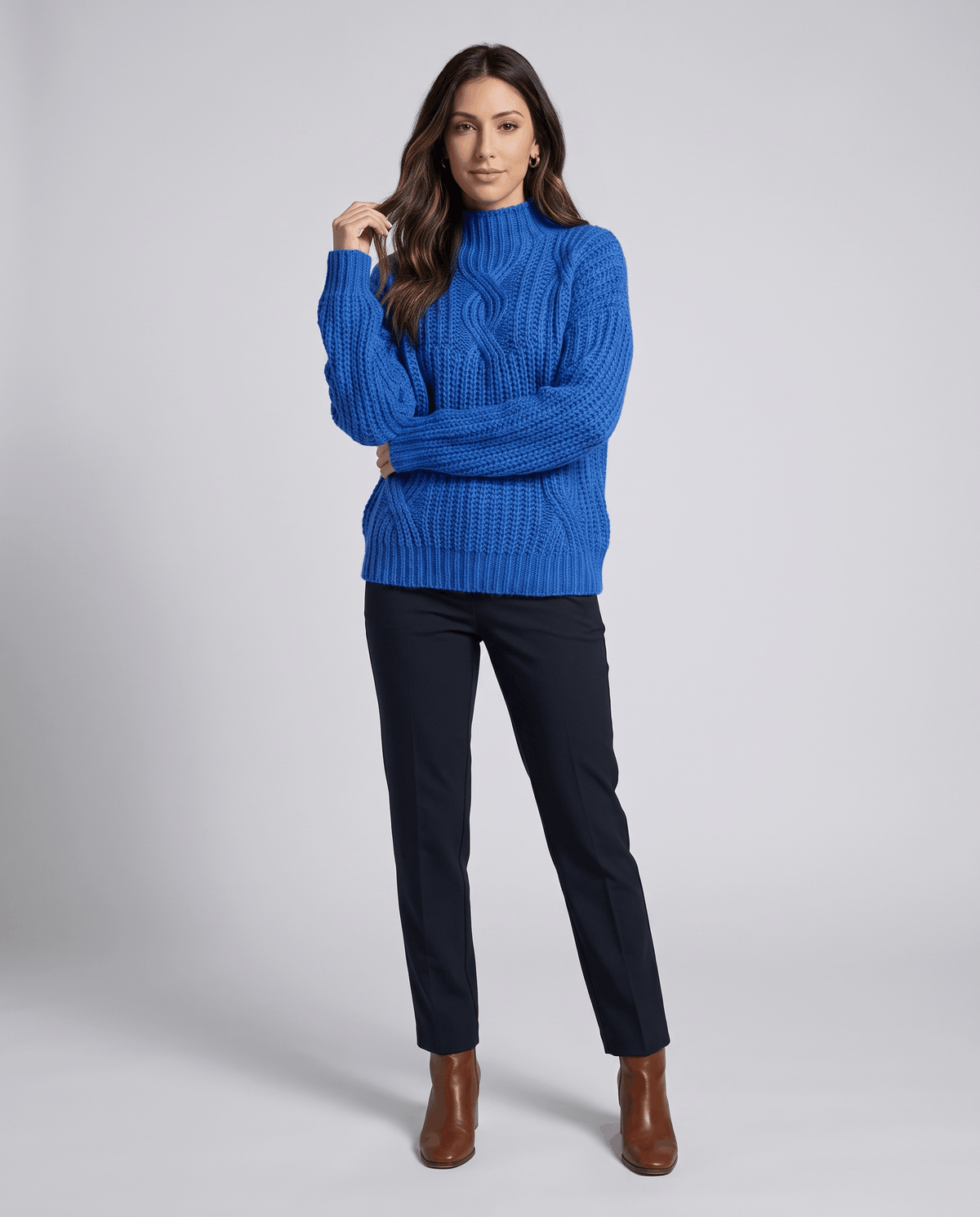 Blue Chunky Cable Knit Sweater worn by a female model with dark pants and boots, featuring a mock neck, relaxed fit, chunky cable knit texture, and long sleeves.