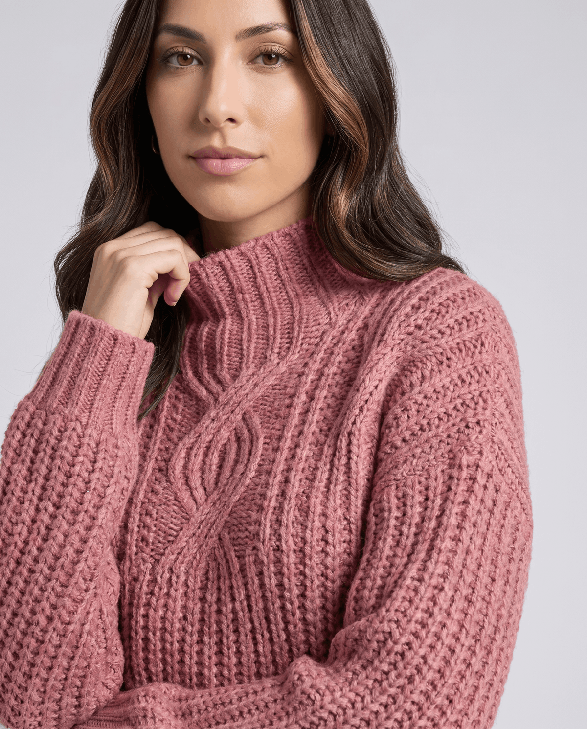 Pink Chunky Cable Knit Sweater worn by a female model, shown from the front with a mock neck, relaxed fit, chunky cable knit texture, and long sleeves.