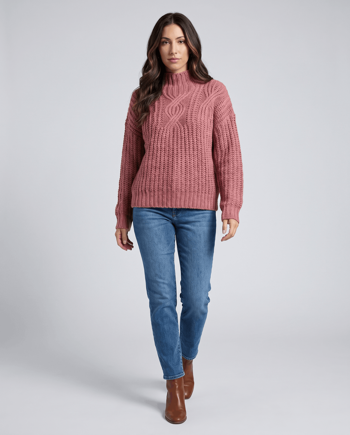 Pink Chunky Cable Knit Sweater worn by a female model with blue jeans, featuring a mock neck, relaxed fit, chunky cable knit texture, and long sleeves.