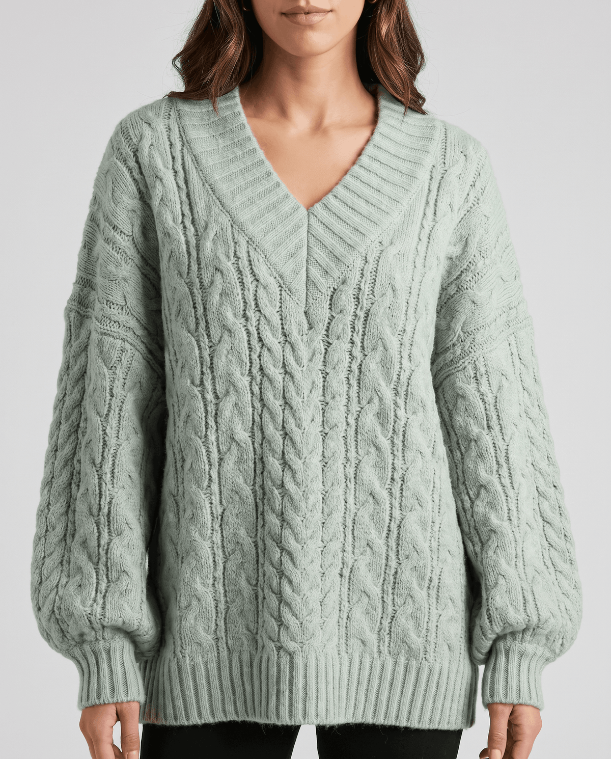 Light green Chunky Cable Knit Sweater worn by a female model, shown from the front with a V-neckline, oversized fit, textured cable knit pattern, and long sleeves.
