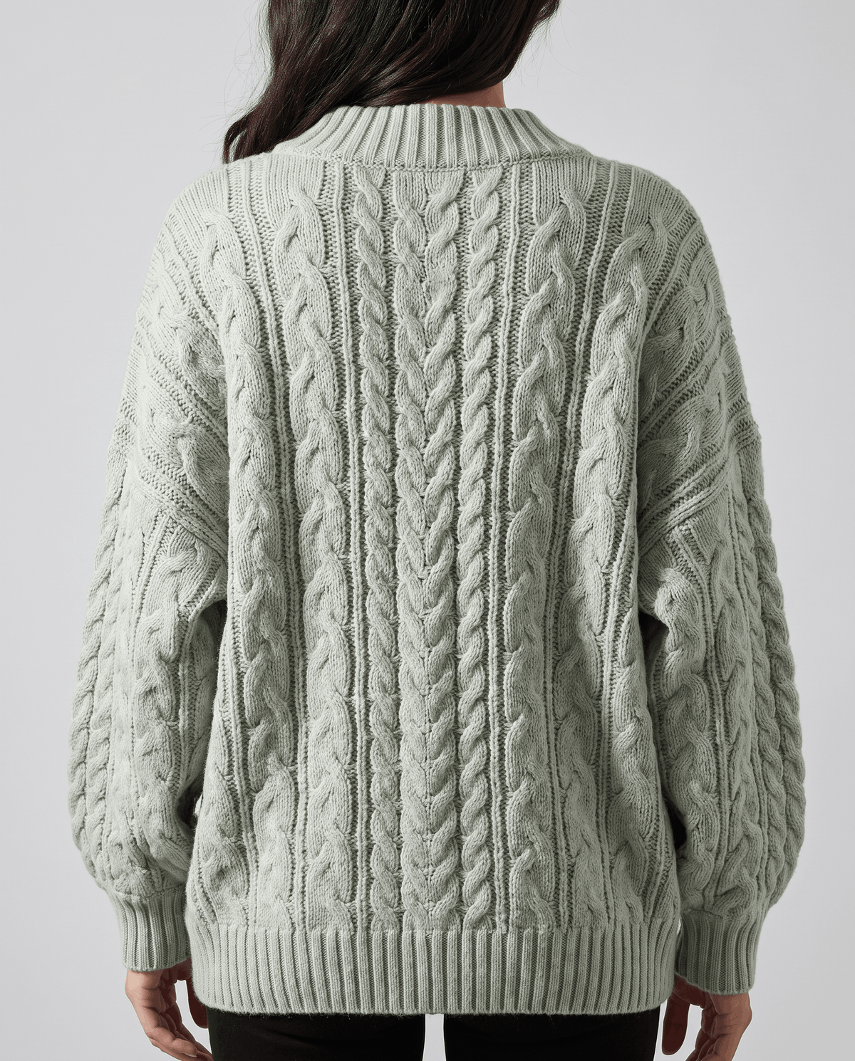 Light green Chunky Cable Knit Sweater worn by a female model from the back, showcasing the textured cable knit pattern, oversized silhouette, and long sleeves.