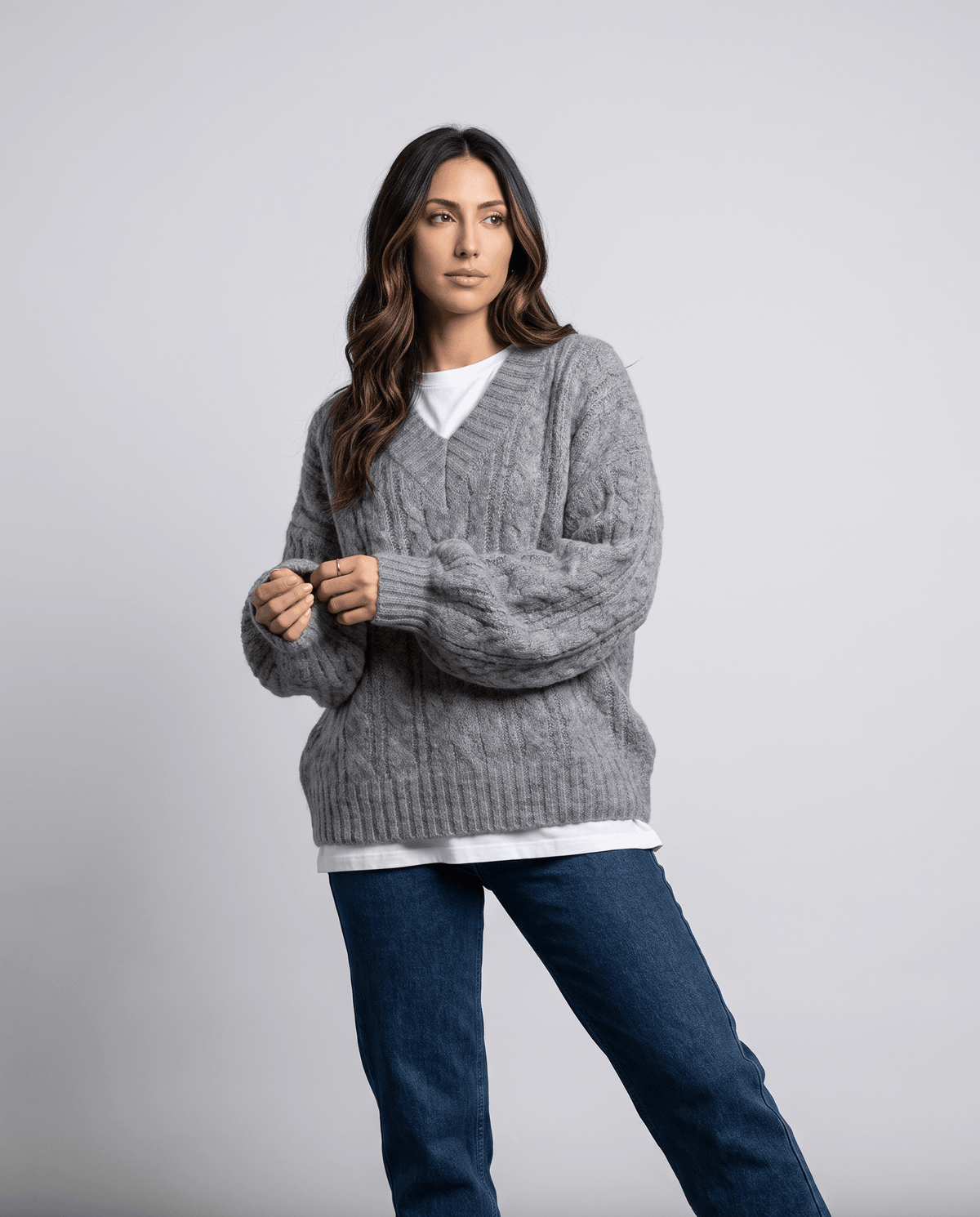Gray Chunky Cable Knit Sweater worn by a female model with blue jeans, featuring an oversized fit, textured cable knit pattern, long sleeves, and relaxed silhouette.