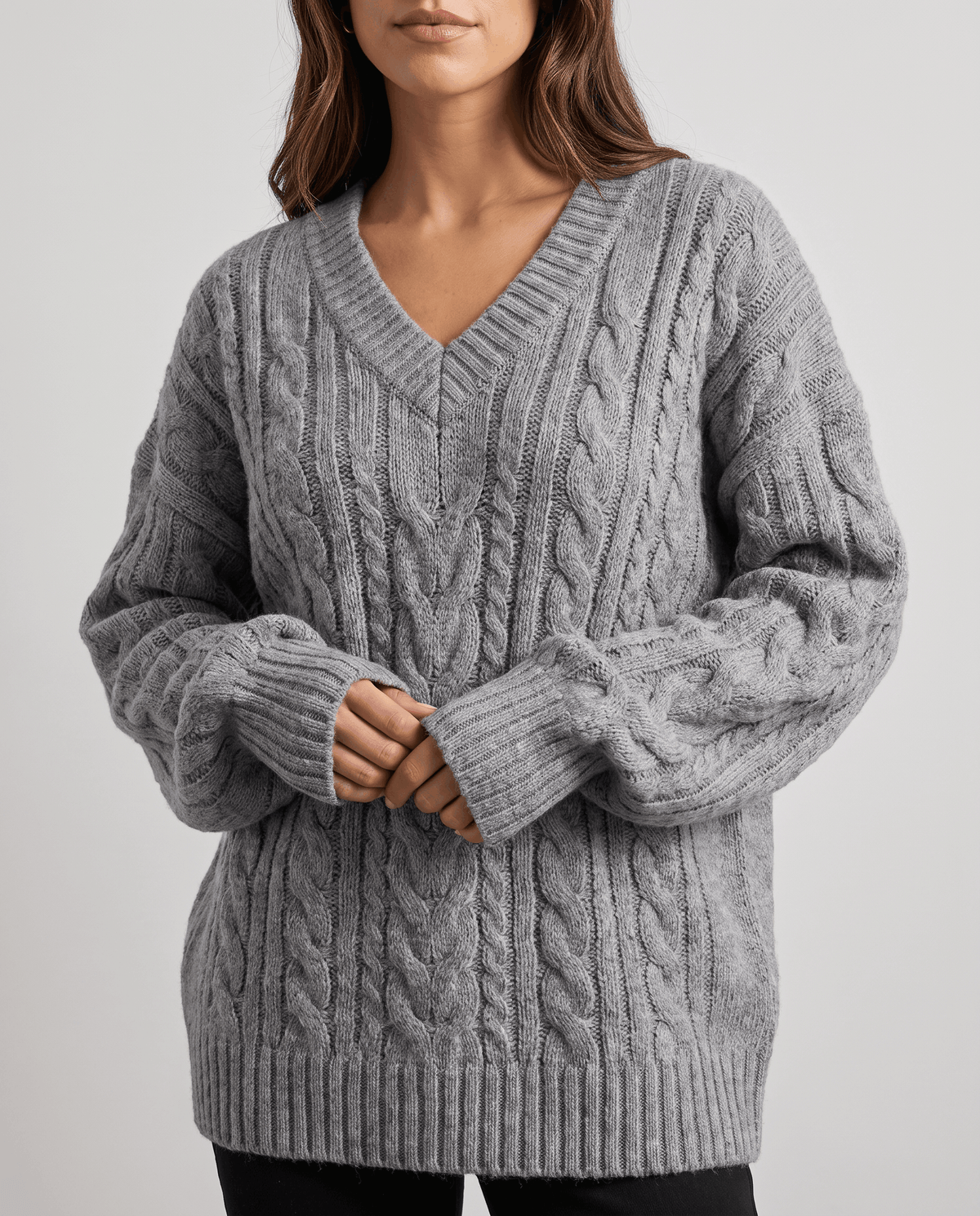 Gray Chunky Cable Knit Sweater worn by a female model, shown from the front with a V-neckline, oversized fit, textured cable knit pattern, and long sleeves.