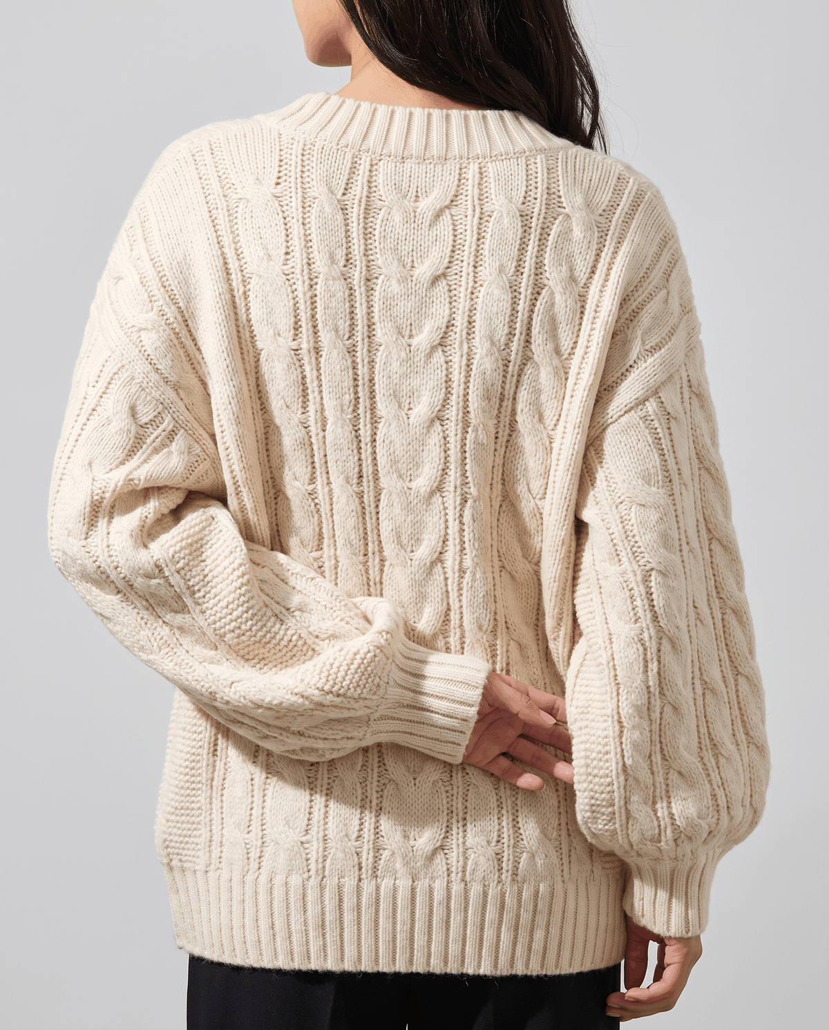 Cream Chunky Cable Knit Sweater worn by a female model from the back, highlighting the chunky cable knit texture, oversized silhouette, and long sleeves.