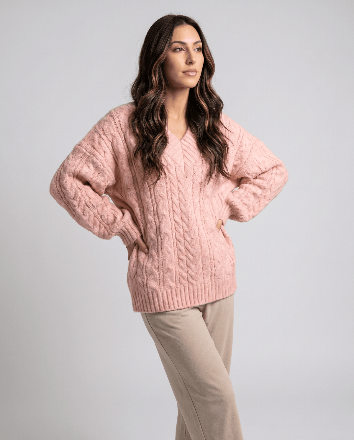 Pink Chunky Cable Knit Sweater worn by a female model, featuring an oversized fit, textured cable knit pattern, long sleeves, and relaxed silhouette.