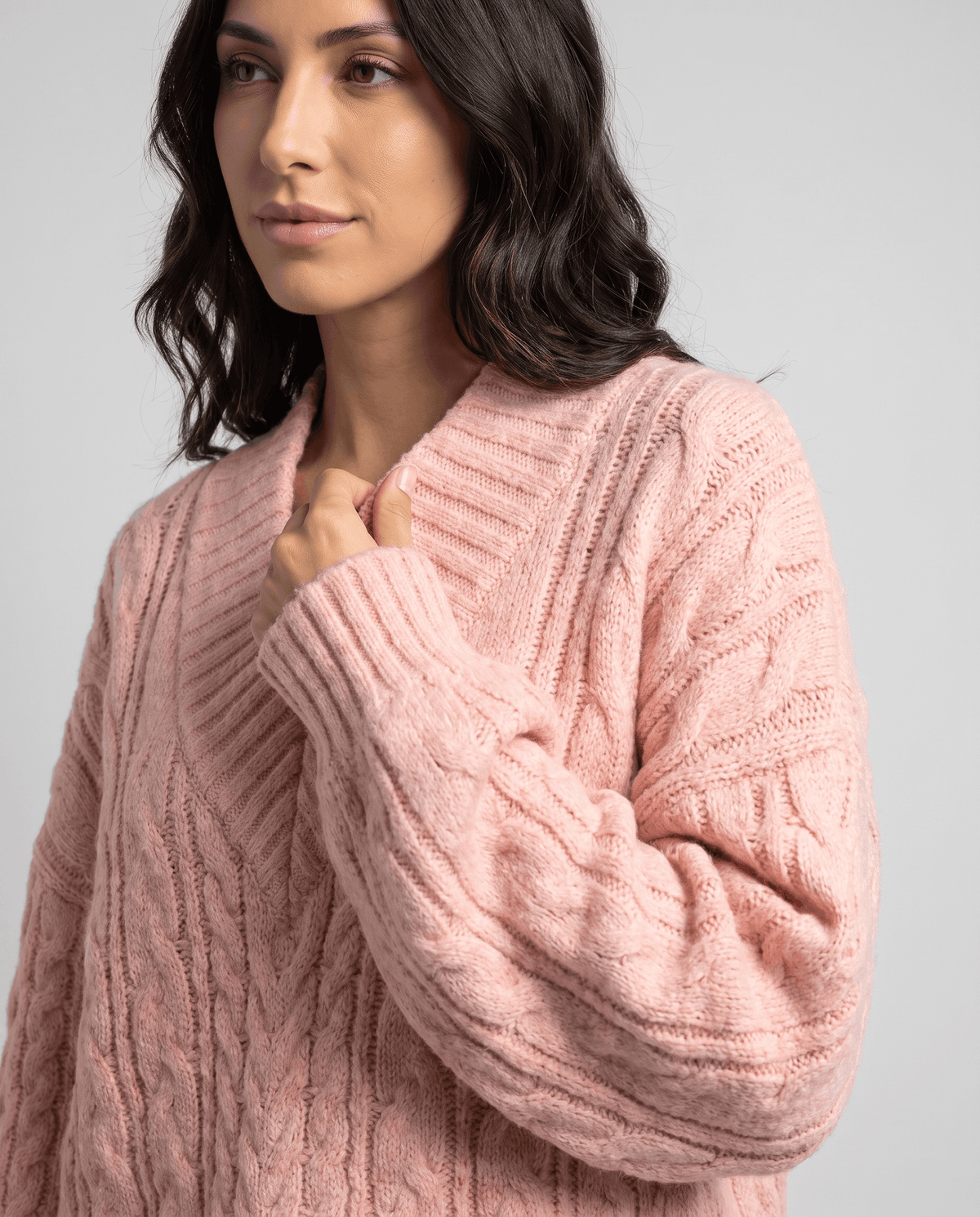 Pink Chunky Cable Knit Sweater worn by a female model, shown in close-up to highlight the chunky cable knit texture, oversized fit, and long sleeves.