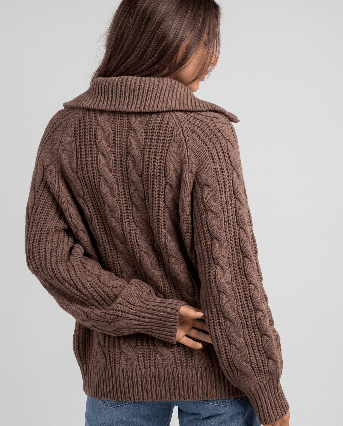 Brown Chunky Cable Knit Sweater worn by a female model from the back, showcasing the stand collar, textured cable knit pattern, half-zip closure, and relaxed fit.