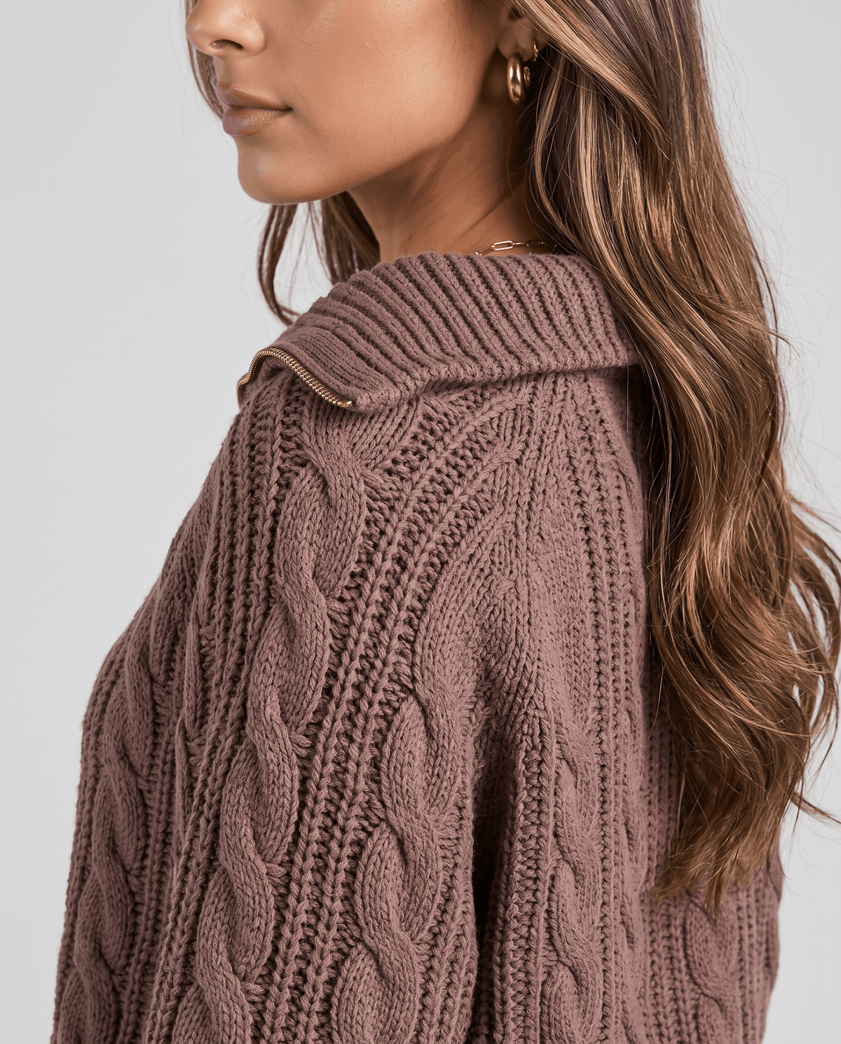 Close-up of the brown Chunky Cable Knit Sweater worn by a female model from the side, highlighting the stand collar and chunky cable knit texture.