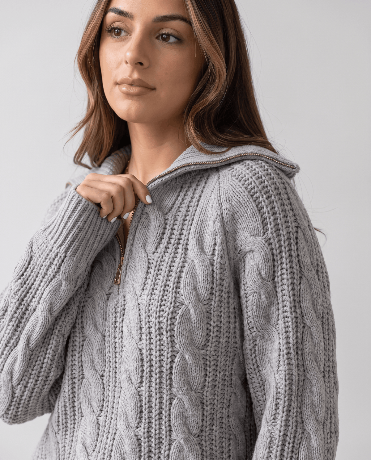 Gray Chunky Cable Knit Sweater worn by a female model, shown in close-up with a stand collar, half-zip front, textured cable knit pattern, and relaxed fit.