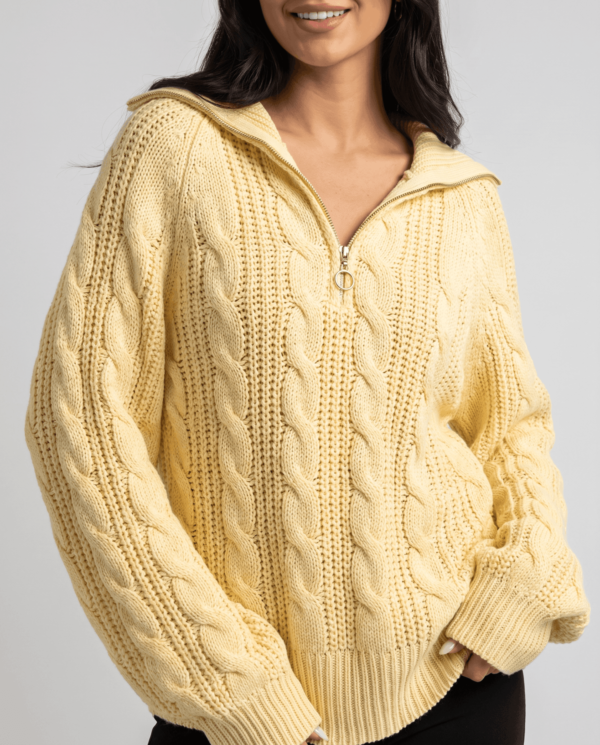 Yellow Chunky Cable Knit Sweater worn by a female model, shown in close-up with a stand collar, half-zip front, chunky cable knit texture, and relaxed fit.