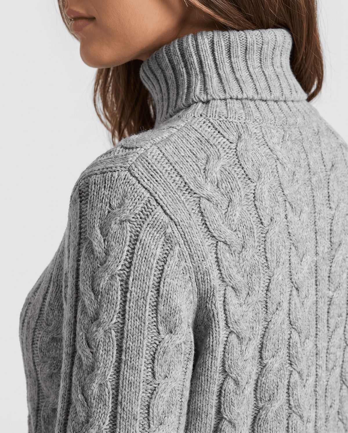 Close-up of the gray Chunky Cable Knit Sweater worn by a female model, highlighting the turtleneck collar, cable knit texture, and ribbed trim.