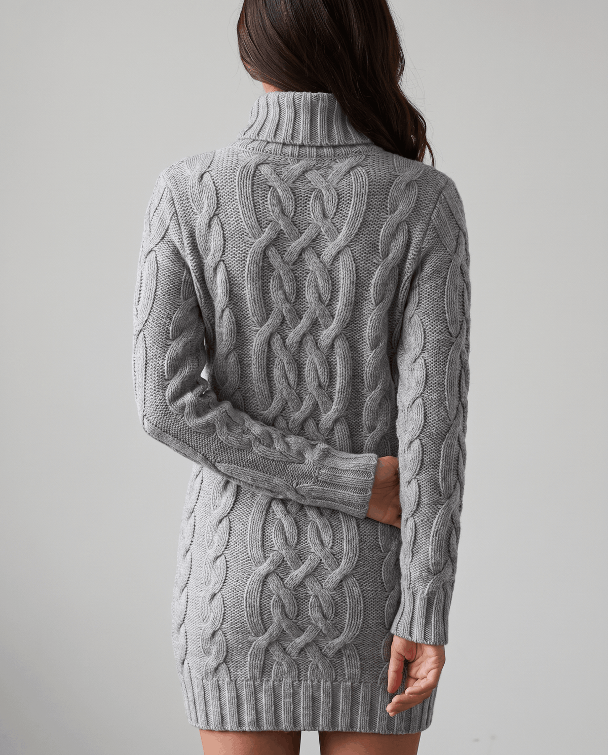 Gray Chunky Cable Knit Sweater worn by a female model from the back, showcasing the textured cable knit pattern, turtleneck, long sleeves, and ribbed hem.