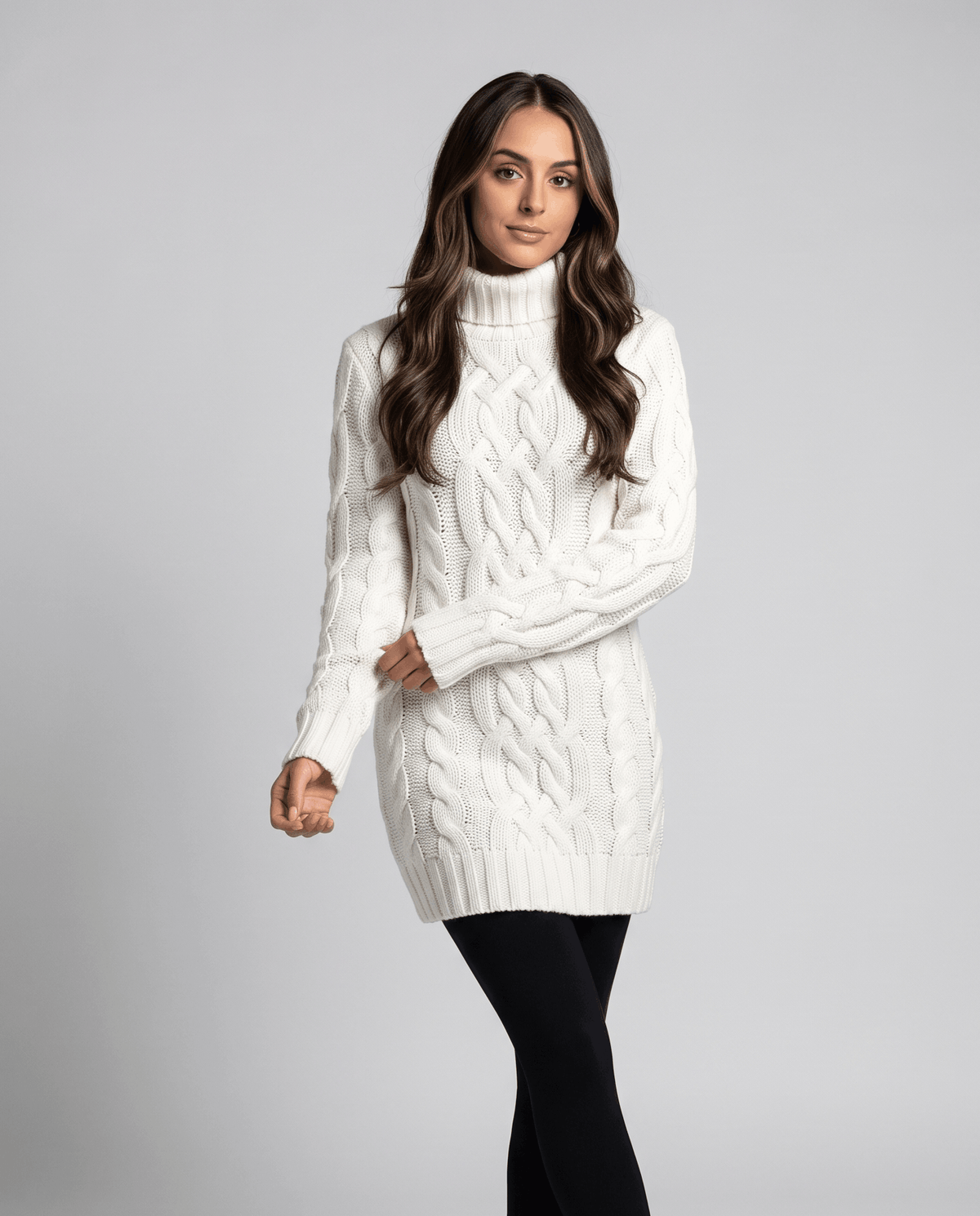 White Chunky Cable Knit Sweater worn by a female model with black leggings, featuring a turtleneck, textured cable knit pattern, long sleeves, and ribbed trim.