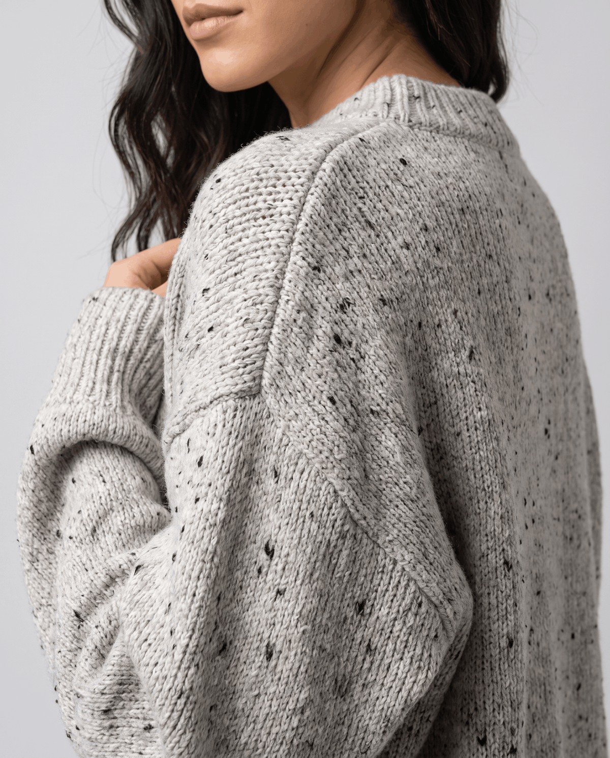 Beige Chunky Knit Sweater worn by a female model from the side, showcasing the textured knit pattern, oversized fit, and long balloon sleeve.