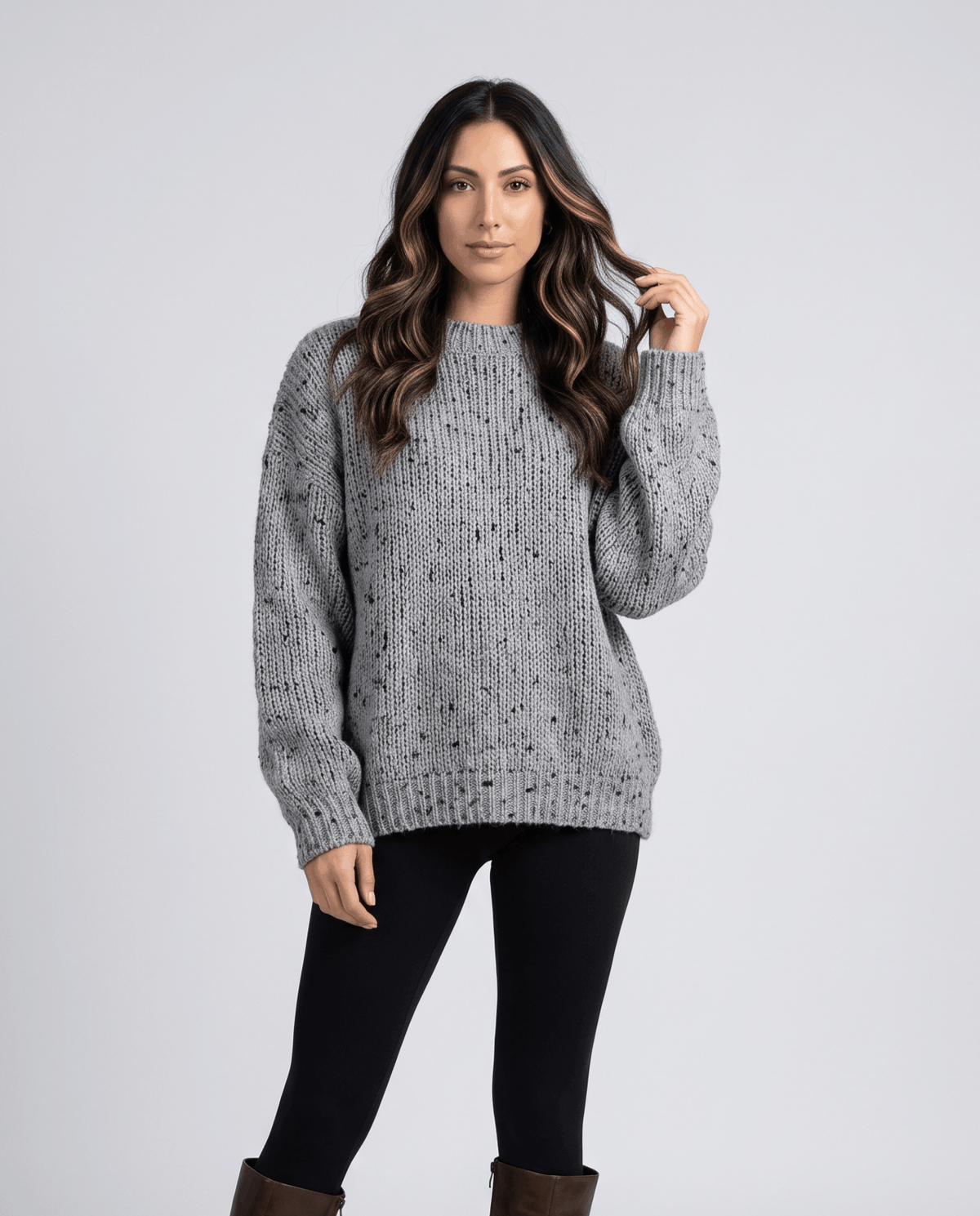 Gray Chunky Knit Sweater worn by a female model with black leggings, featuring an oversized fit, textured chunky knit pattern, and long balloon sleeves.