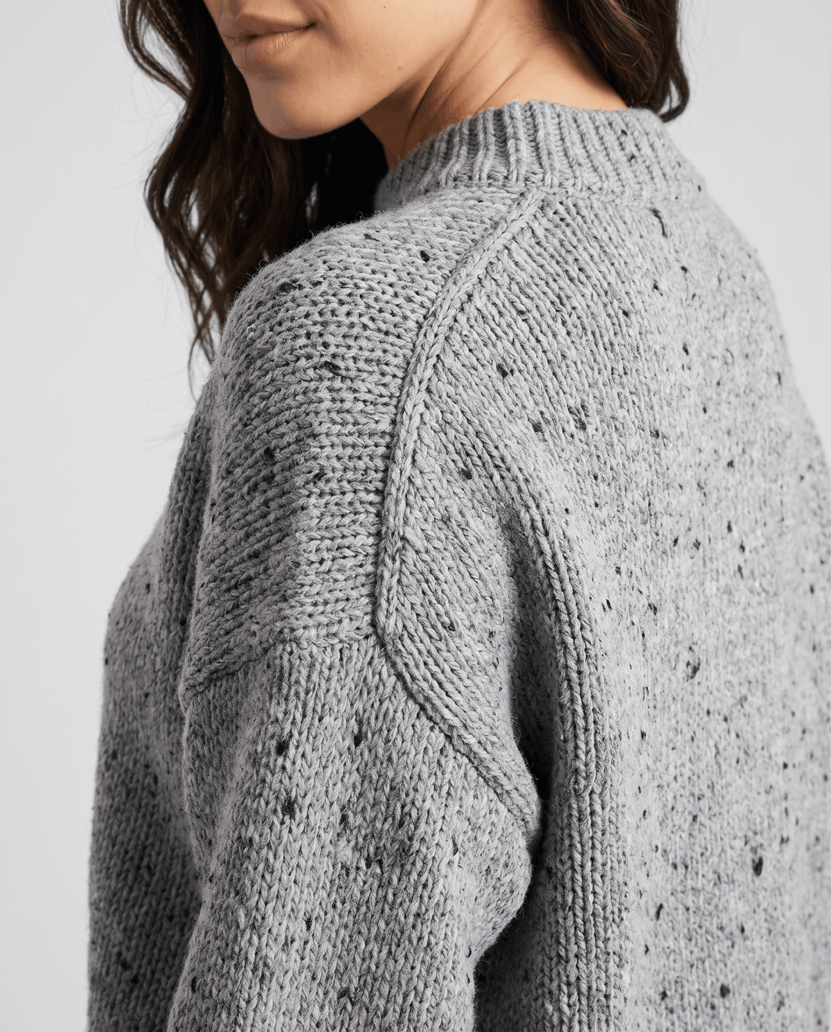 Close-up of the gray Chunky Knit Sweater worn by a female model, highlighting the chunky knit texture, rounded neckline, and relaxed fit.