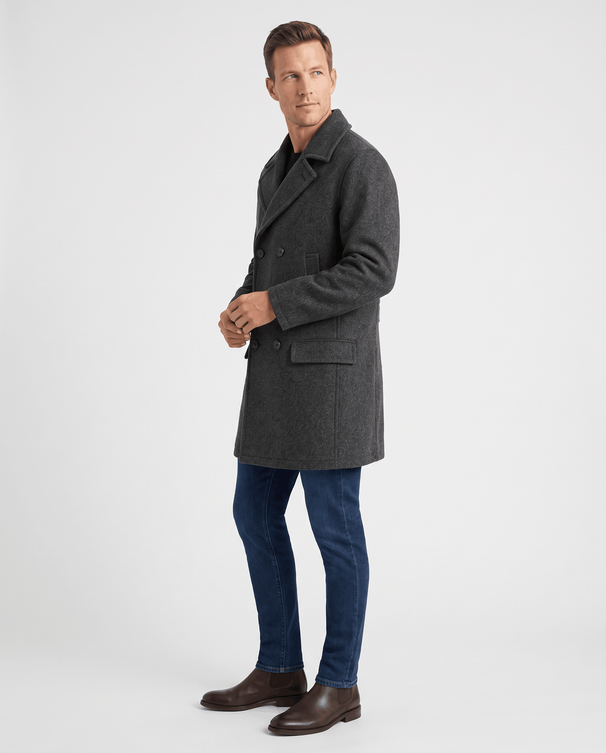 A man wearing a gray classic double-breasted trench coat with a longline fit and tailored lapels, shown in side view
