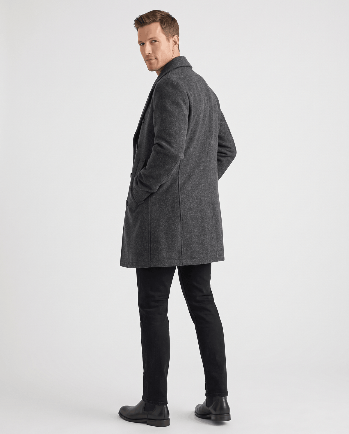 A man wearing a gray classic double-breasted trench coat with a longline fit and tailored lapels, shown from the back