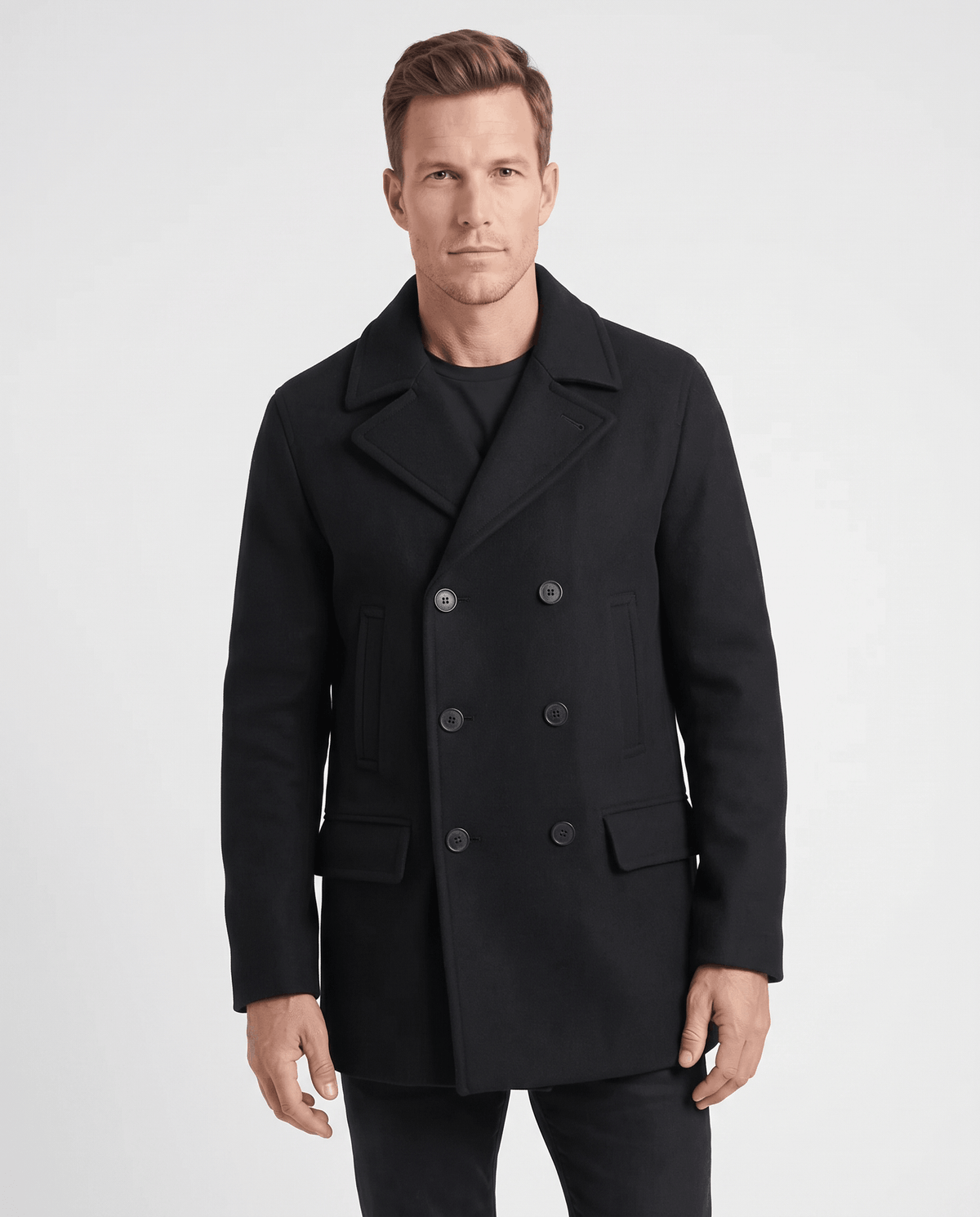 Black double-breasted longline trench coat with tailored lapels worn by a male model