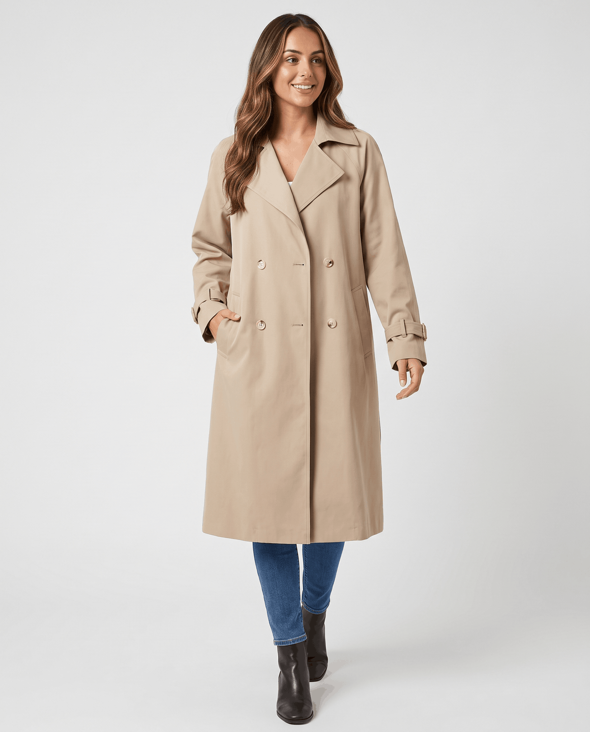 A woman wearing a beige classic trench coat with a lapel collar and double-breasted button closure, full-length view