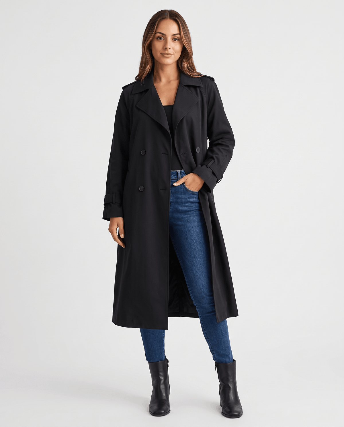 A woman wearing a black classic trench coat with a lapel collar and double-breasted button closure