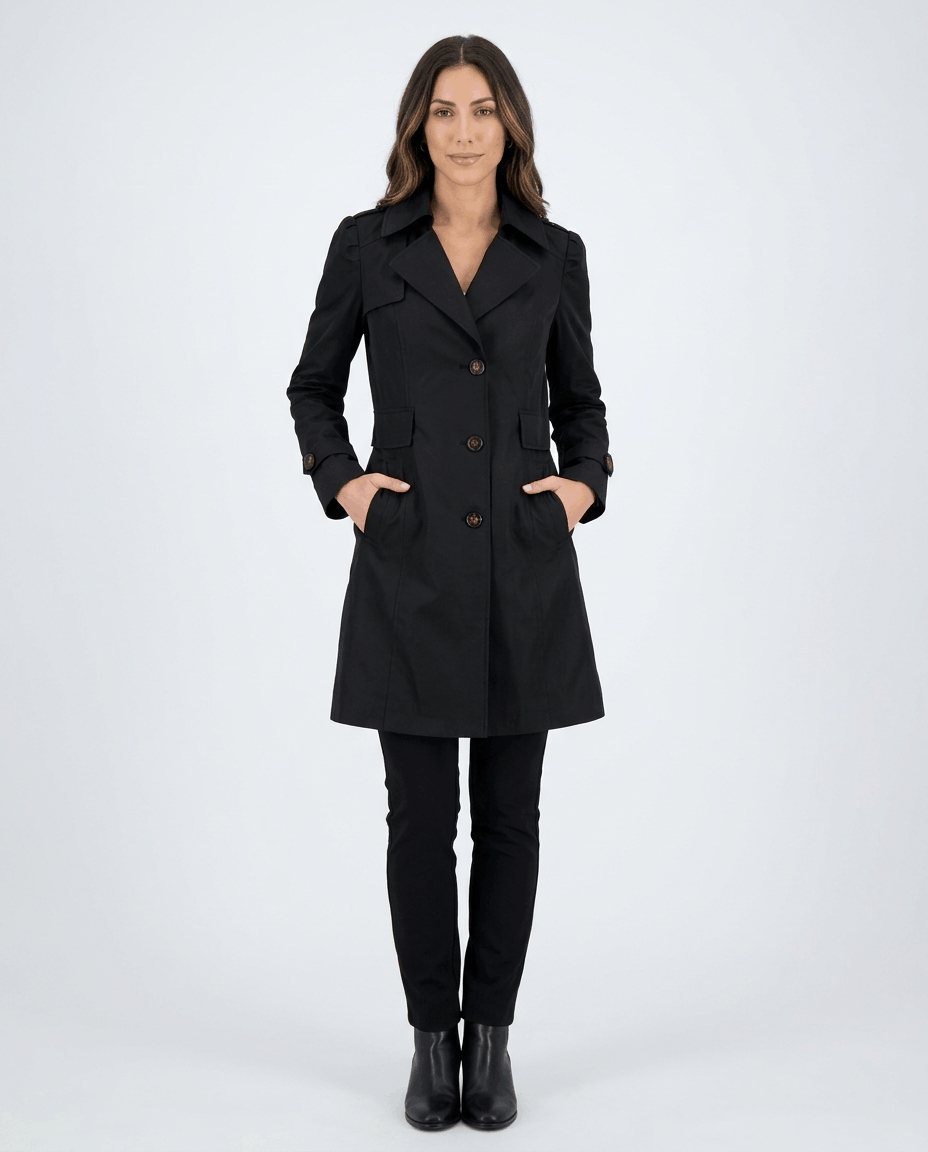 A woman wearing a black classic trench coat with a lapel collar, button front, and adjustable cuffs