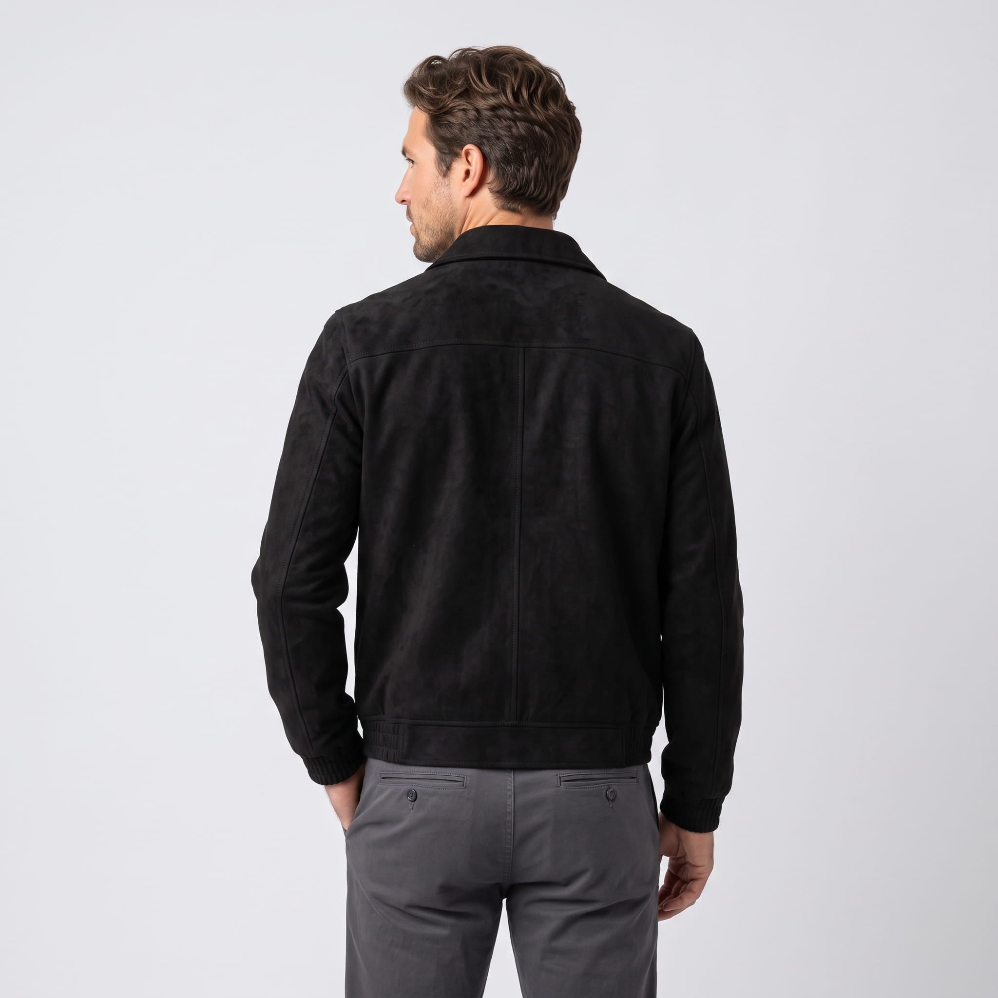 Male model wearing the black jacket, showing the back and ribbed waistband.