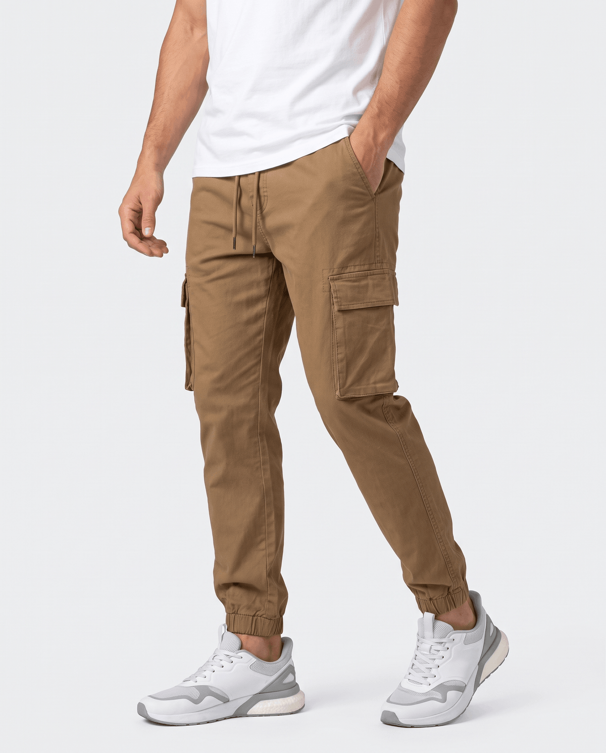 A man wearing brown cotton cargo jogger pants with a tapered fit and utility pockets, shown from the front