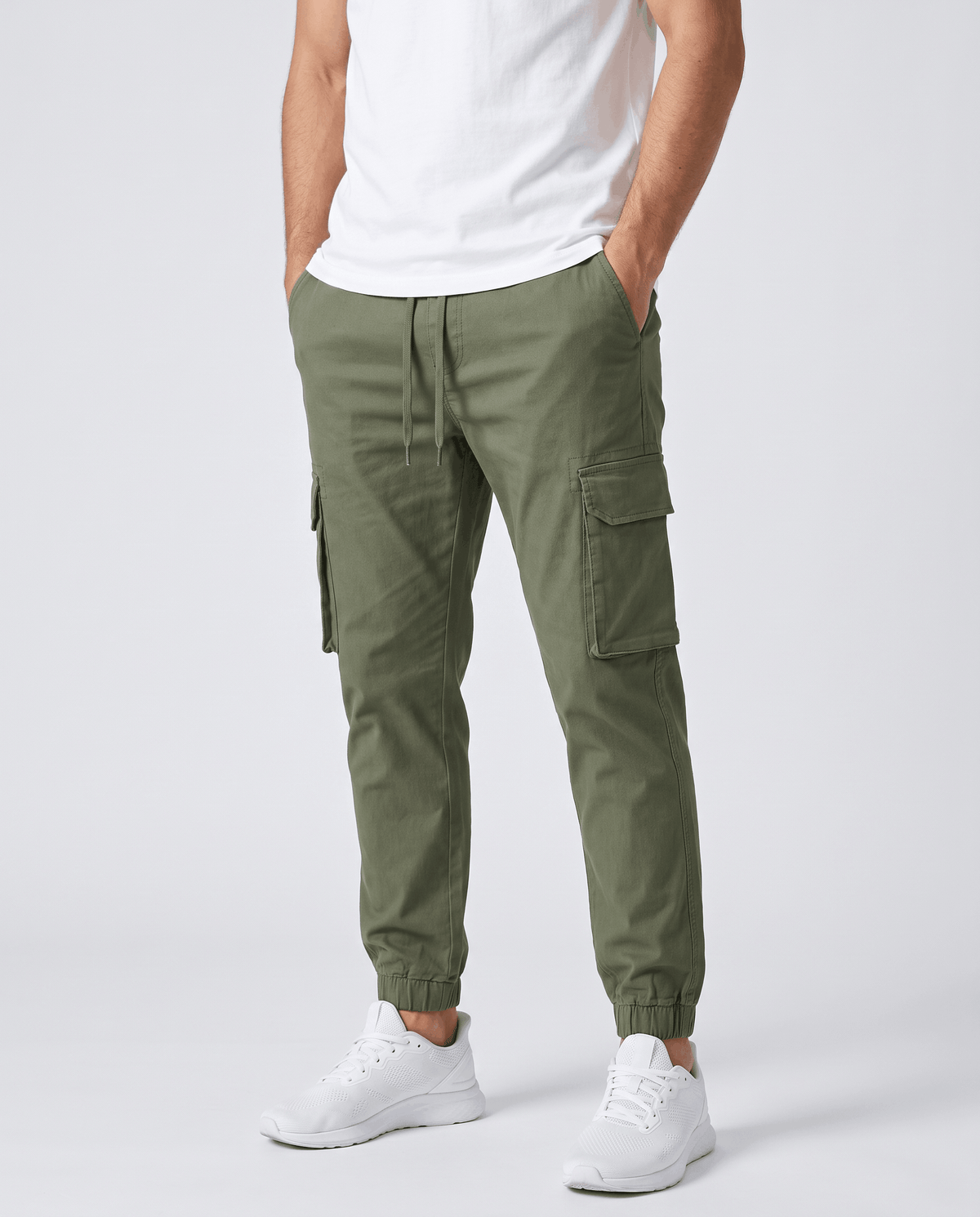 A man wearing olive green cotton cargo jogger pants with a tapered fit and utility pockets, front view