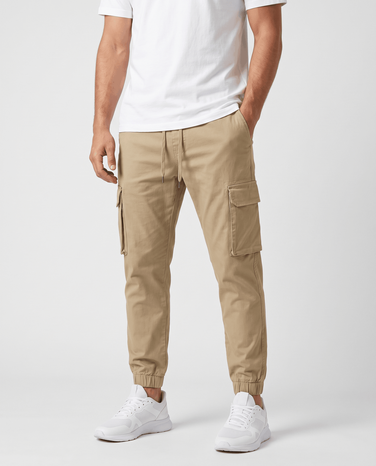 A man wearing khaki cotton cargo jogger pants with a tapered fit and utility pockets, shown from the front