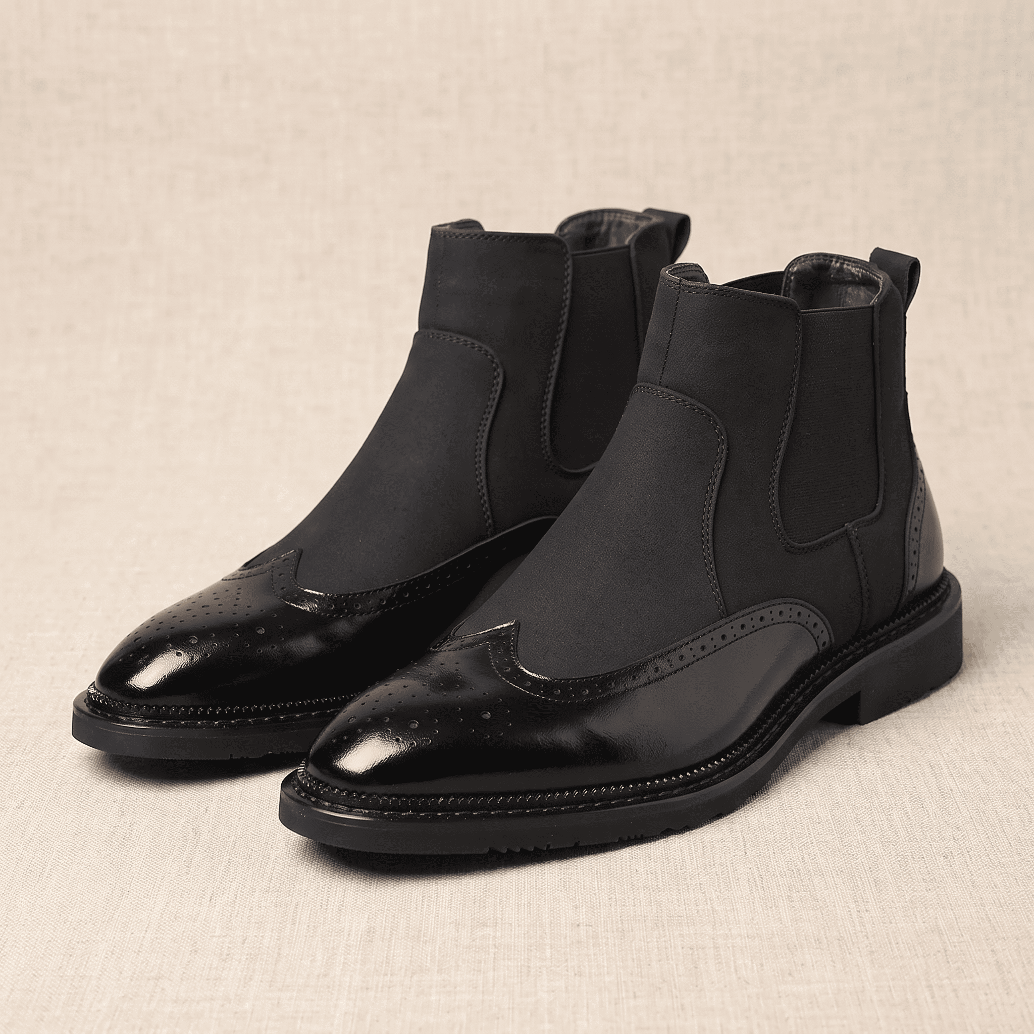 Pair of black leather Chelsea boots displayed together, showing the elastic panels, pull tabs, and polished finish.