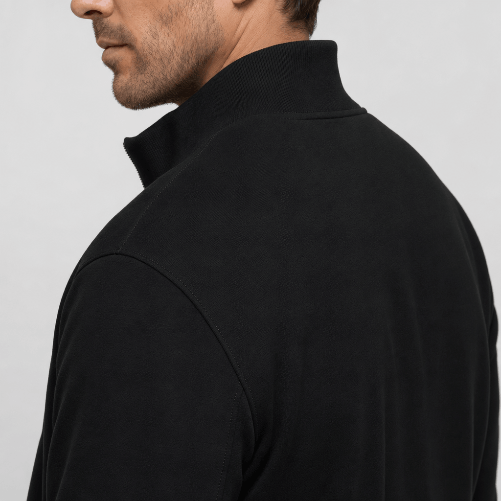 Close-up back and side view of the black jacket, showing the raised collar and shoulder.