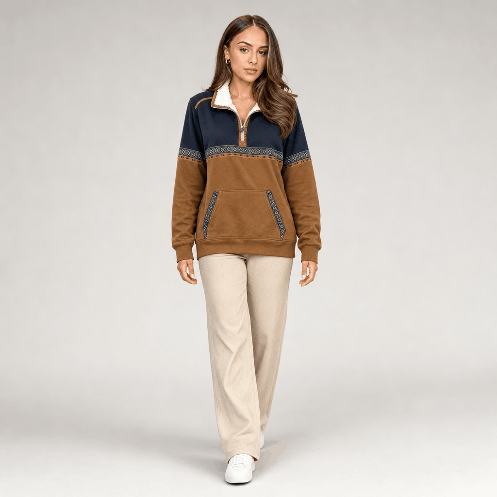 Full-body view of the woman wearing the color-block half-zip pullover with light-colored pants.
