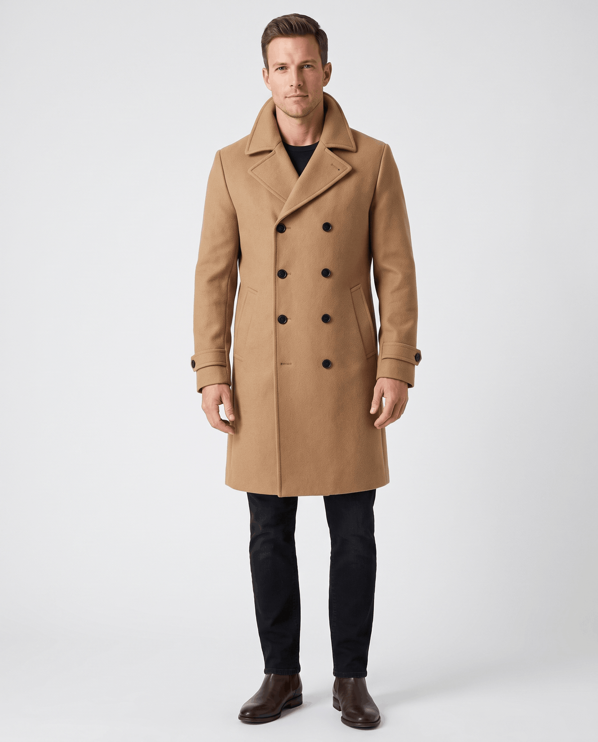 A man wearing a camel double-breasted trench coat with a longline fit, notched lapel, and structured shoulders