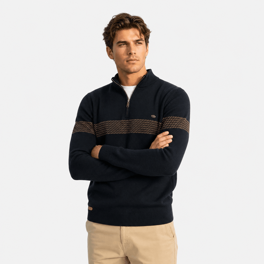 Male model wearing a black quarter-zip sweater with a textured horizontal stripe across the chest, arms crossed.