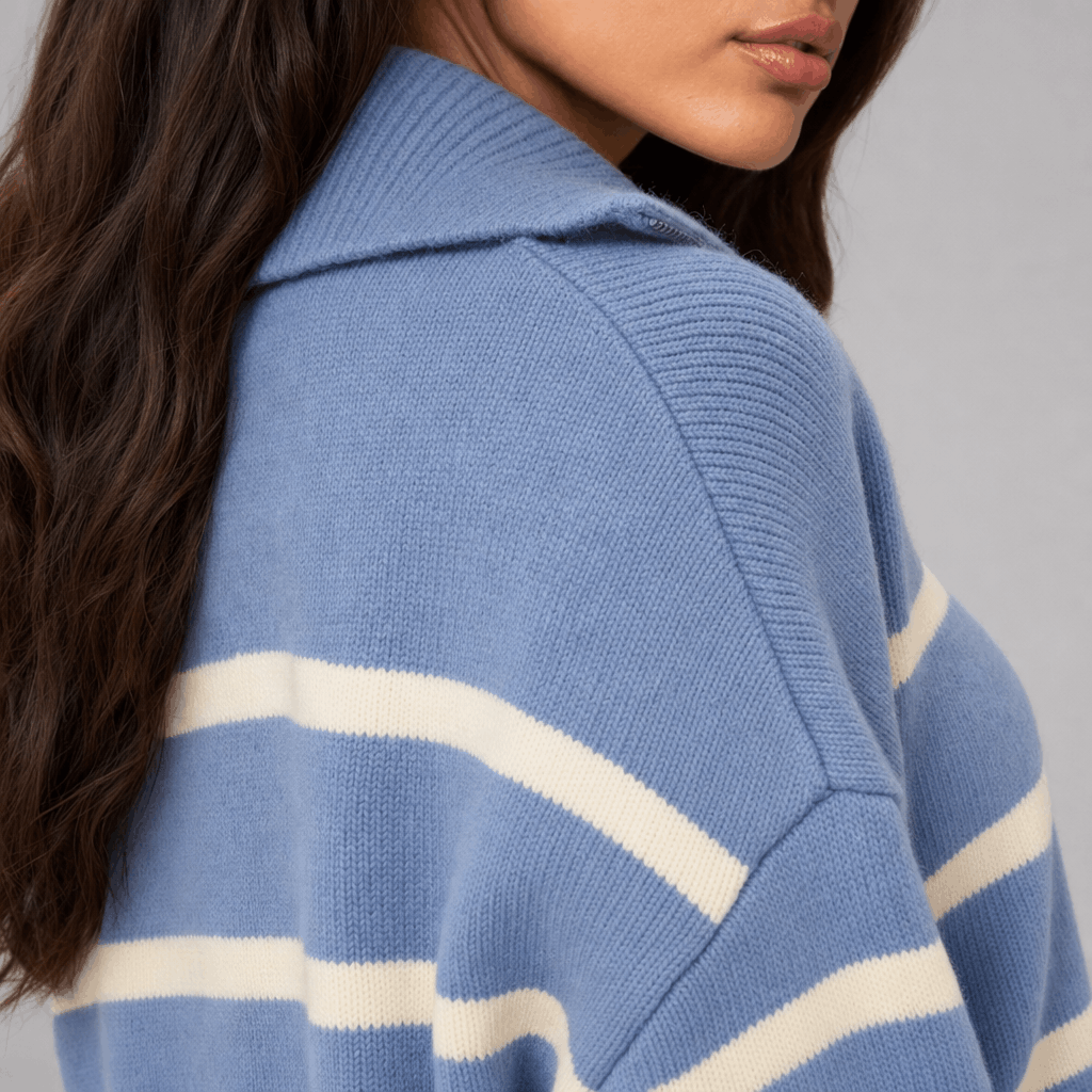 Close-up of the blue striped sweater, showing the raised collar, zipper, and white stripe detail.