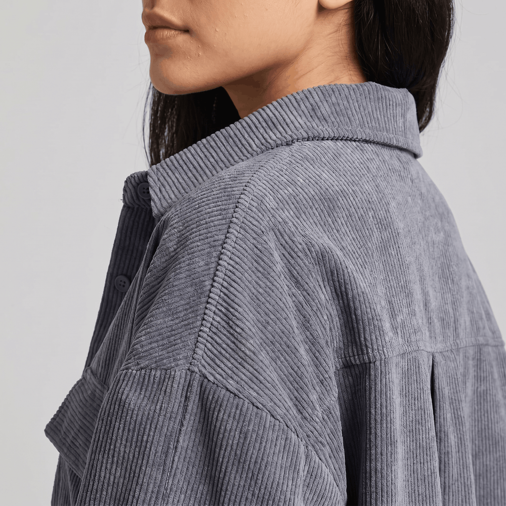 Muted brown corduroy overshirt with a relaxed drop-shoulder fit, button-front closure, and textured ribbed wale fabric.