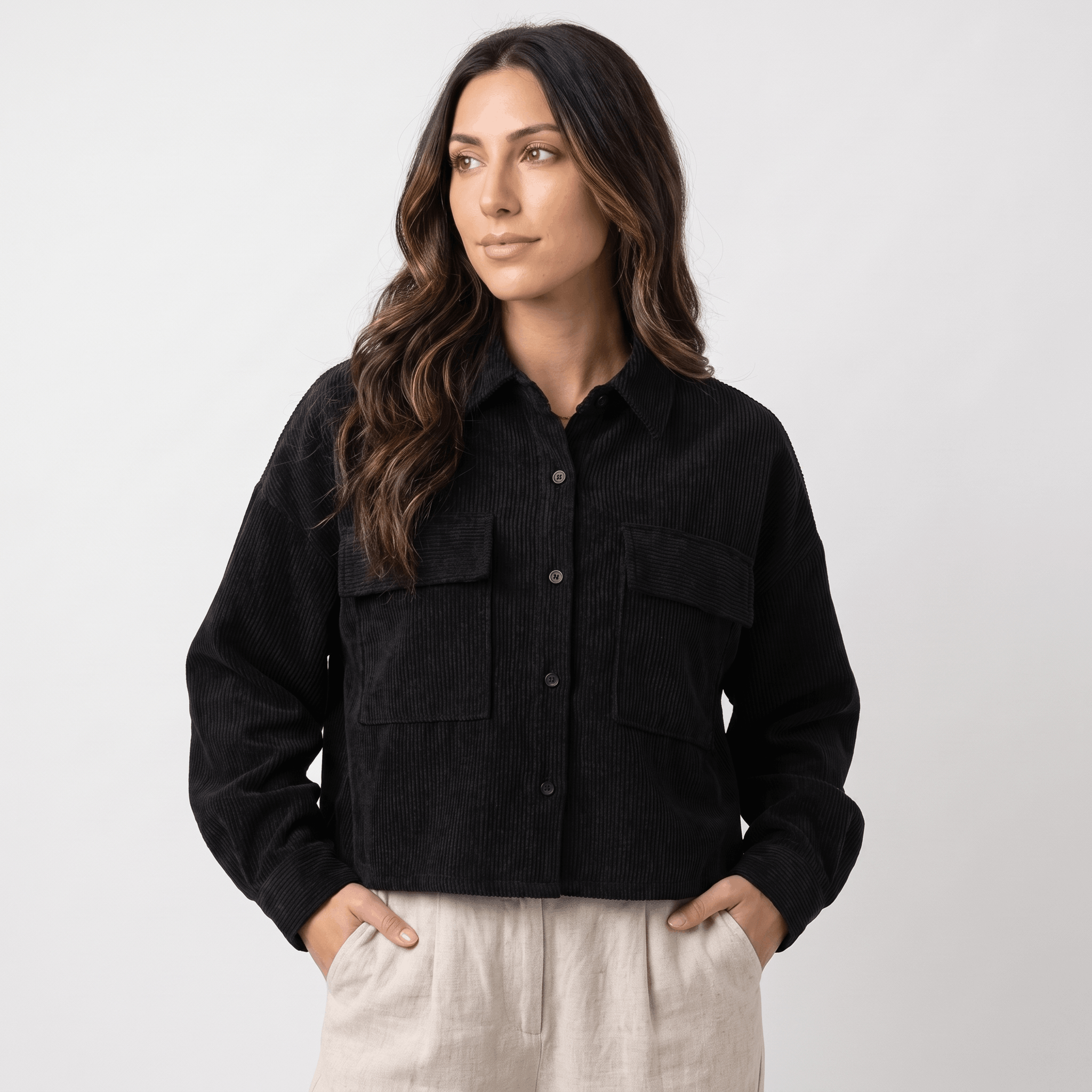 Black corduroy overshirt with a relaxed drop-shoulder fit, button-front closure, and dual chest pockets.