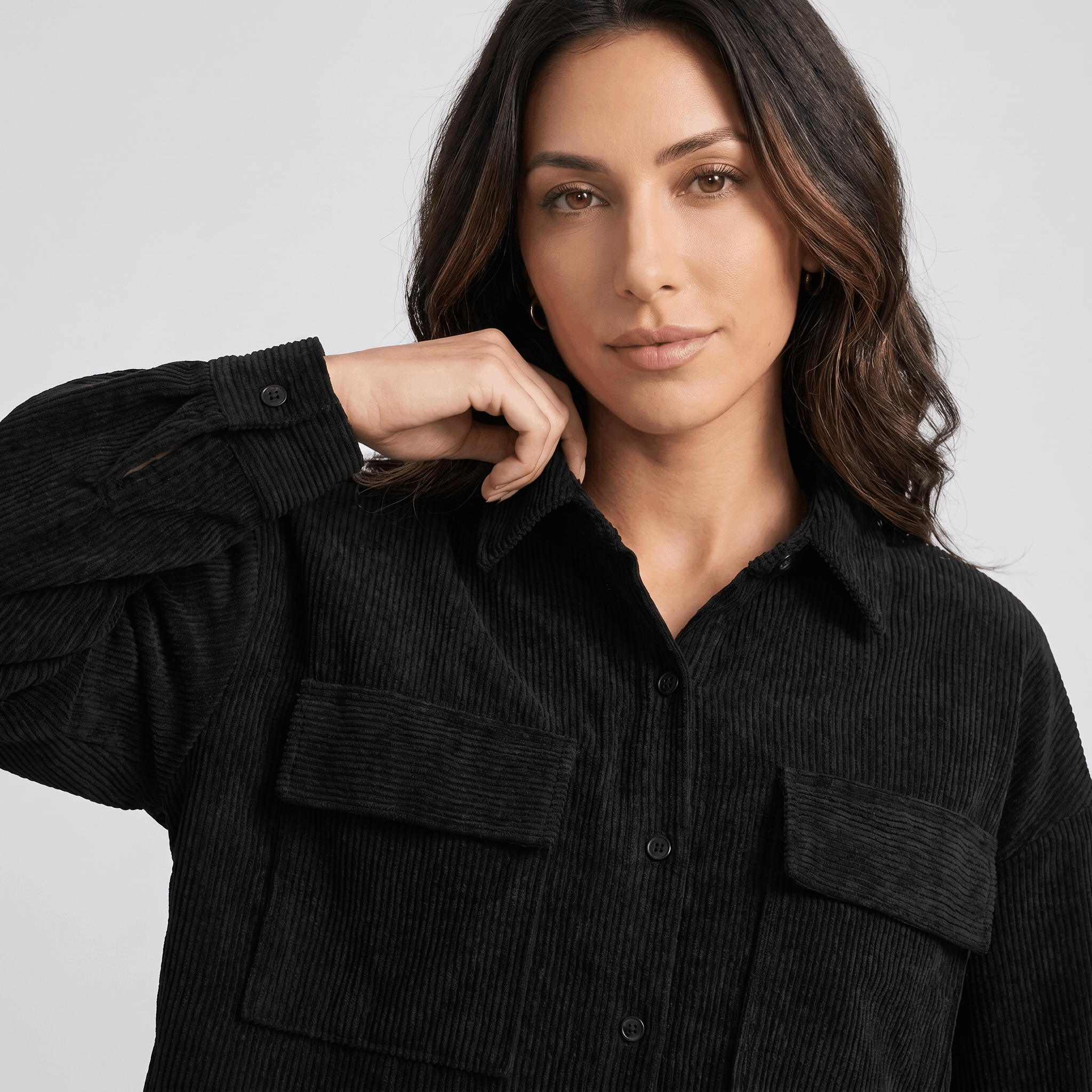 Black corduroy overshirt with a relaxed drop-shoulder fit, button-front closure, and dual chest flap pockets.