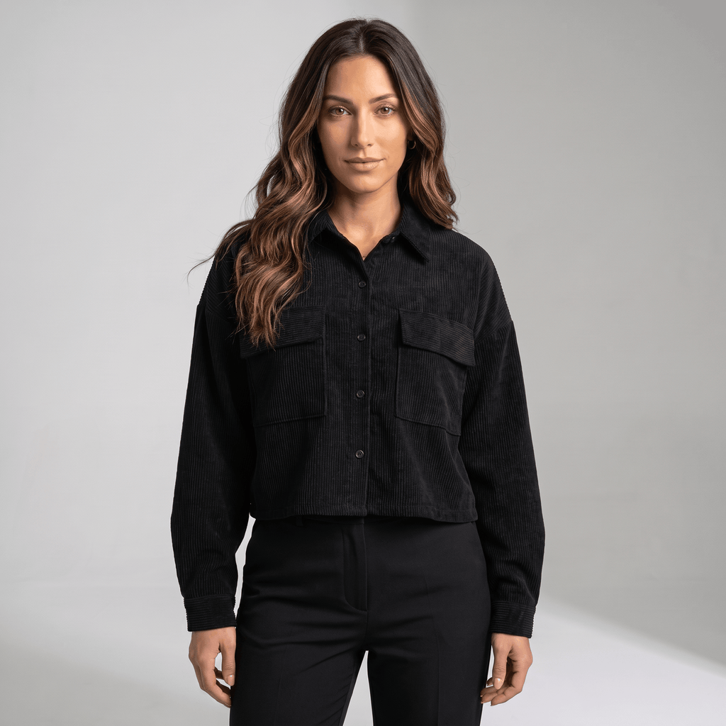 Black corduroy overshirt with a relaxed drop-shoulder fit, button-front closure, and dual flap chest pockets.