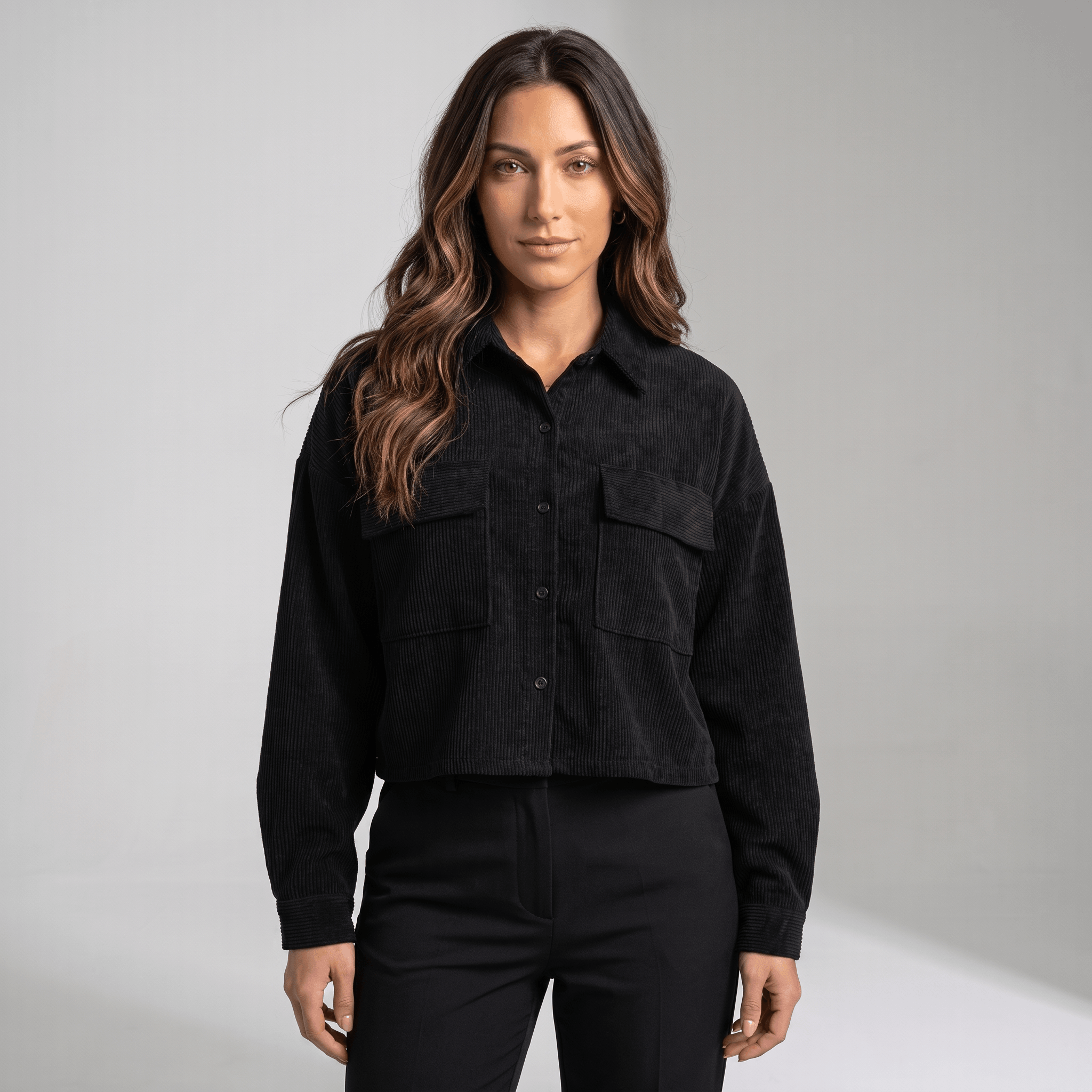 Black corduroy overshirt with a relaxed drop-shoulder fit, button-front closure, and dual flap chest pockets.