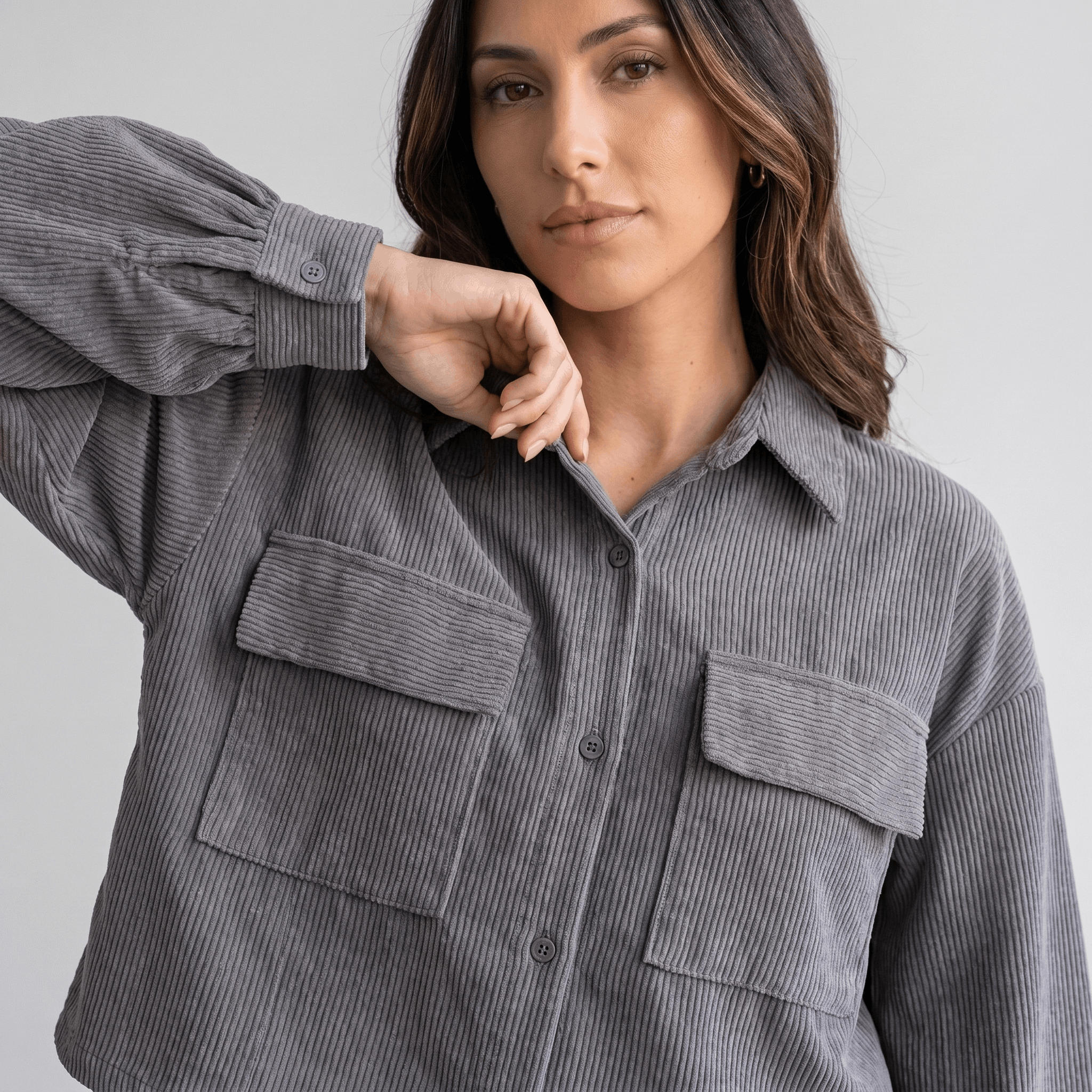 Grey corduroy overshirt with a relaxed drop-shoulder fit, button-front closure, and dual chest flap pockets.