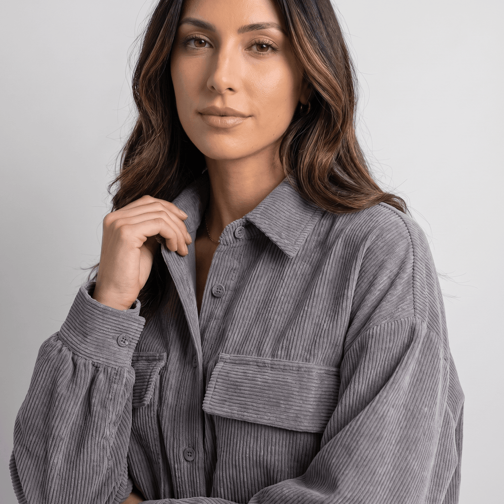Grey corduroy overshirt with a relaxed drop-shoulder fit, button-front closure, and dual chest pockets.