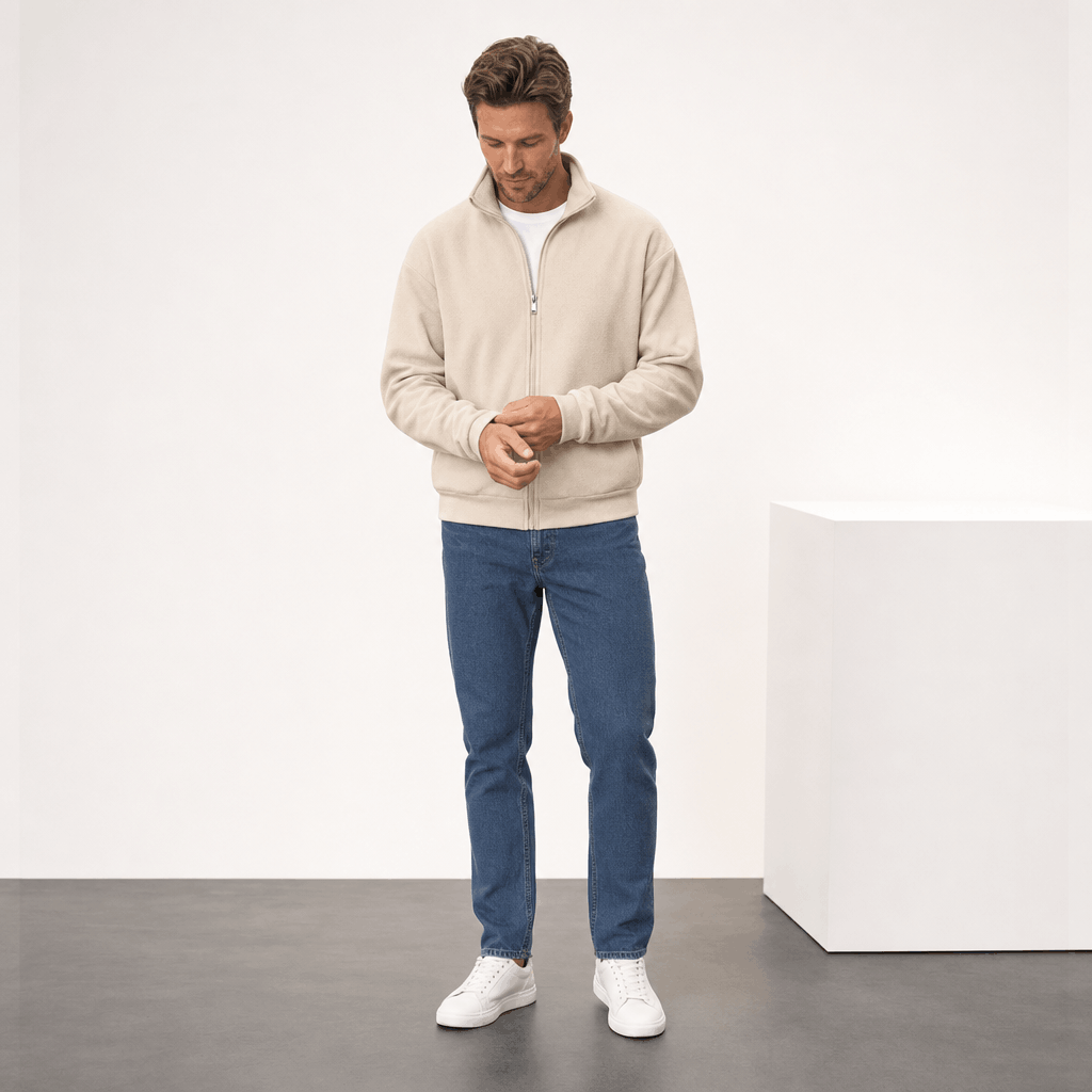 Male model wearing the cream zip-up jacket with blue jeans and white sneakers.