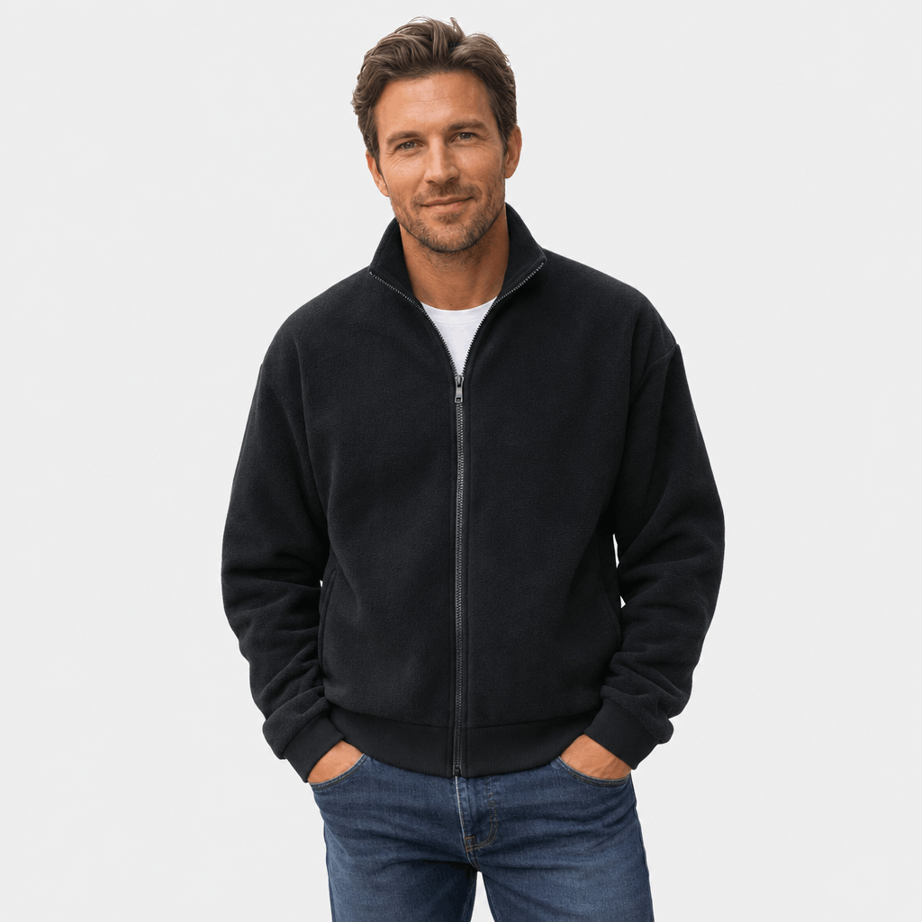 Male model wearing a black zip-up jacket with hands in the side pockets.