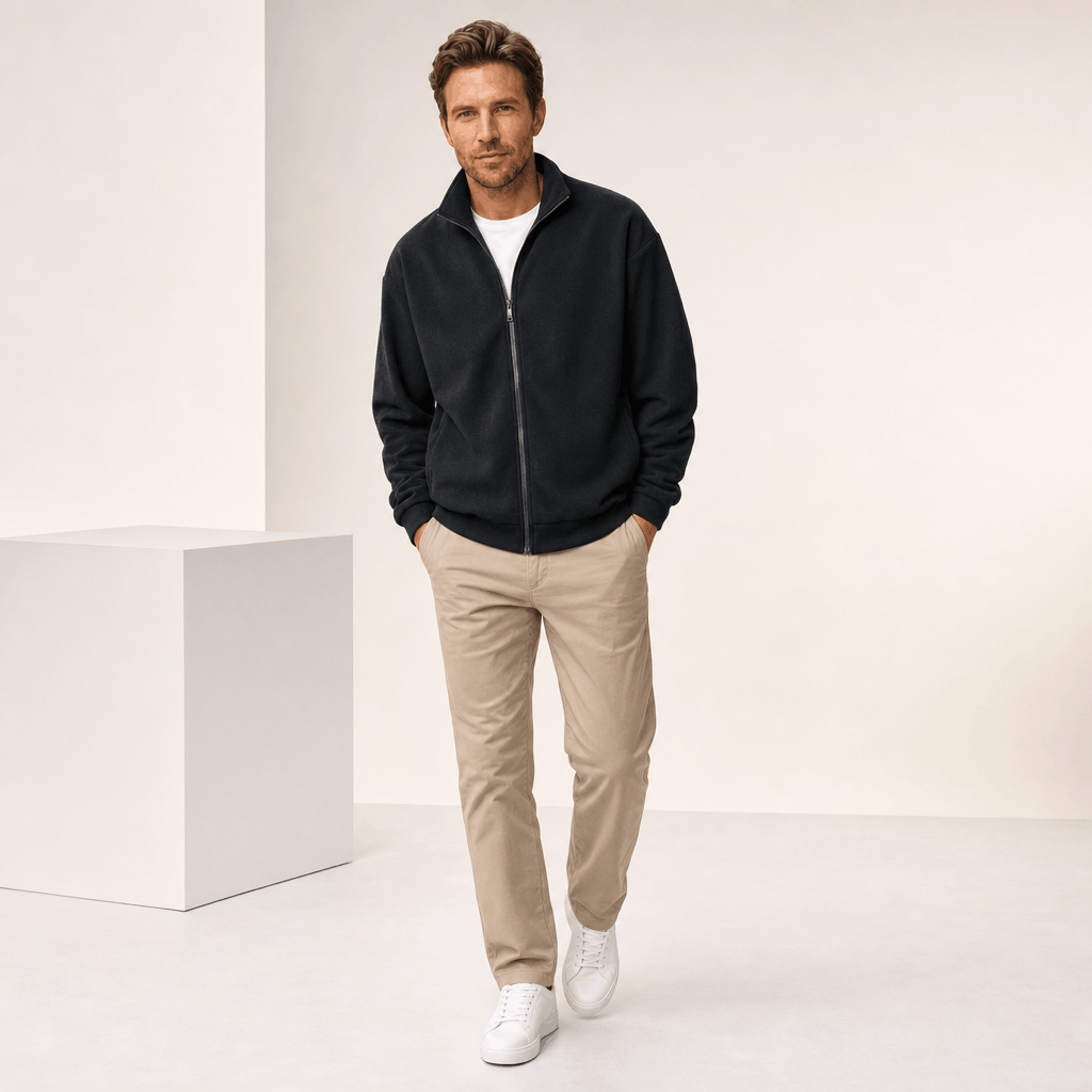 Male model wearing the black zip-up jacket with khaki pants.